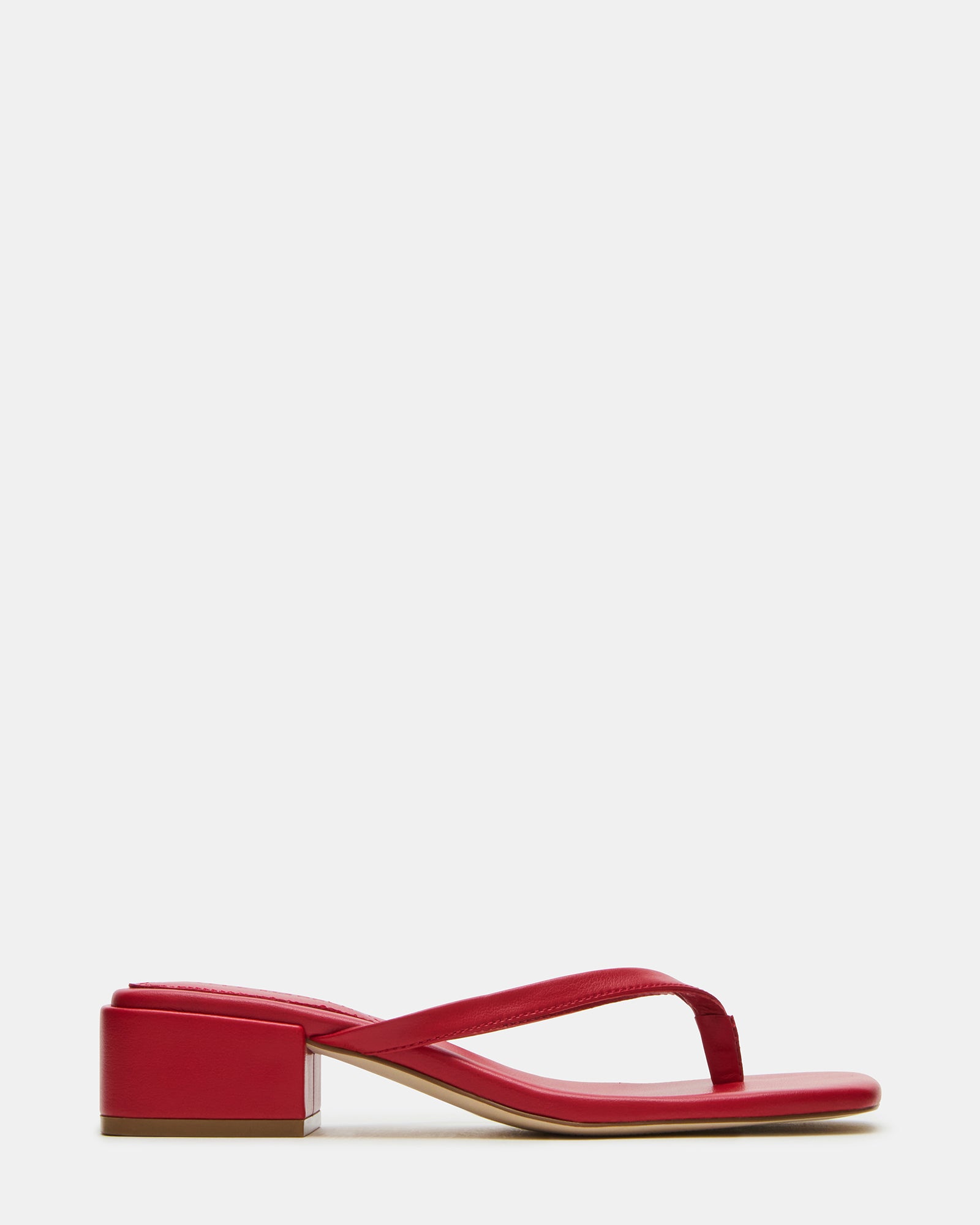 Side view of Caribbean Red square toe mule sandals on a beach.
