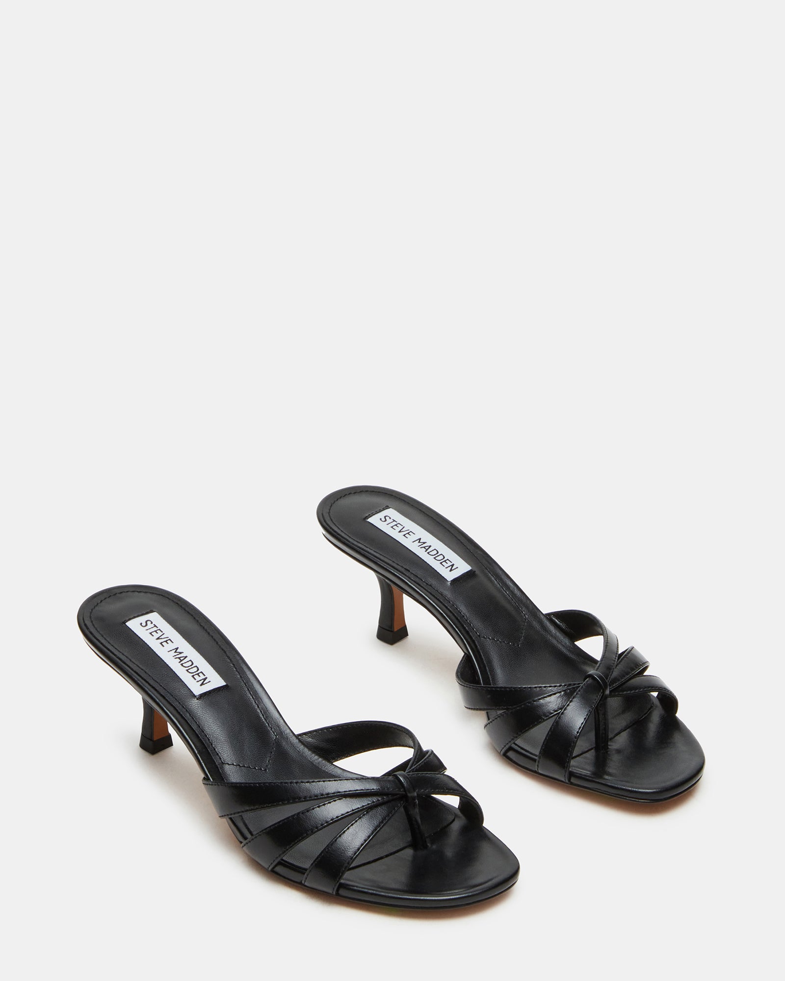 Lifestyle shot of heeled mules black styled with casual outfit on city street