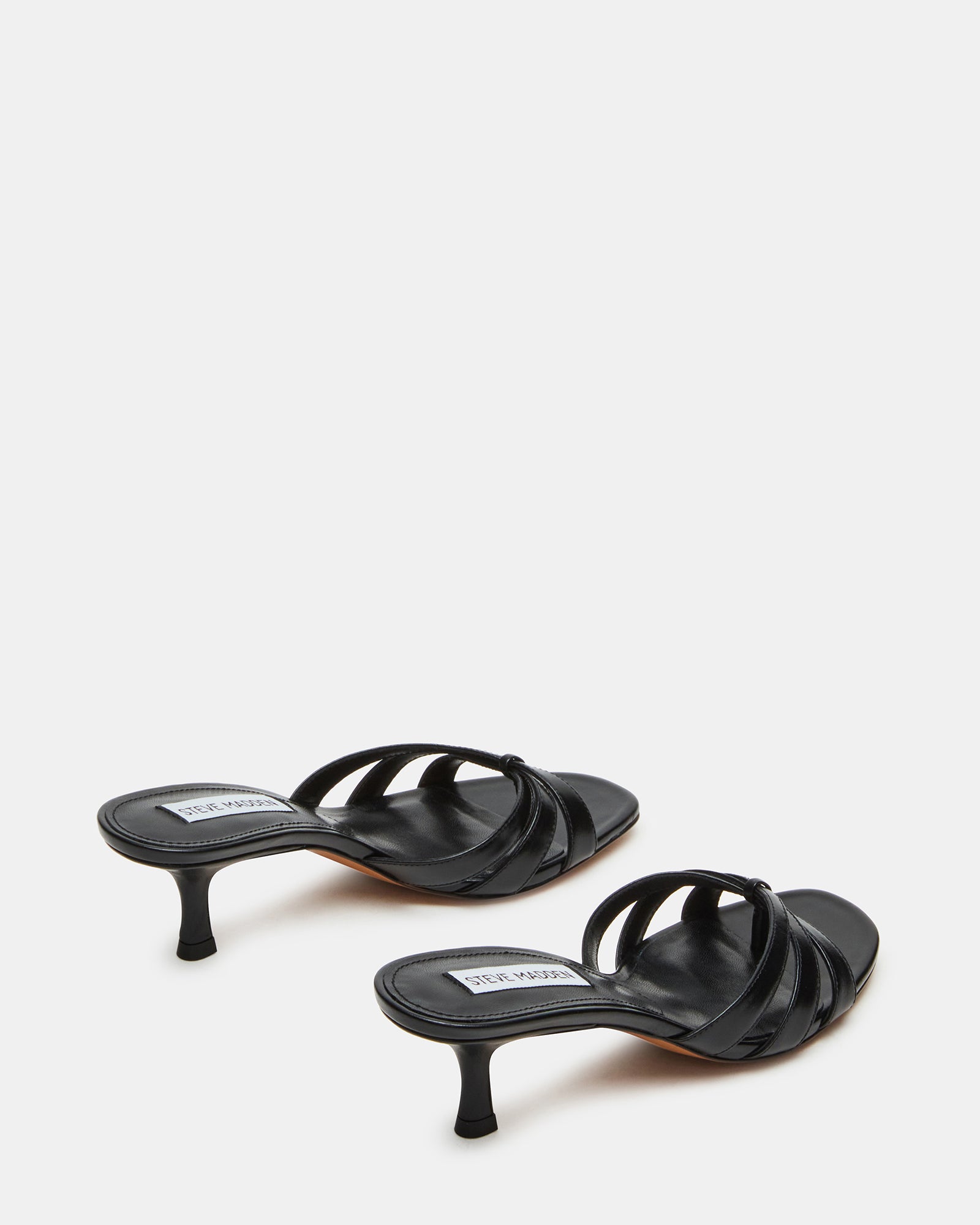 Lifestyle shot of heeled mules black styled with casual outfit on city street