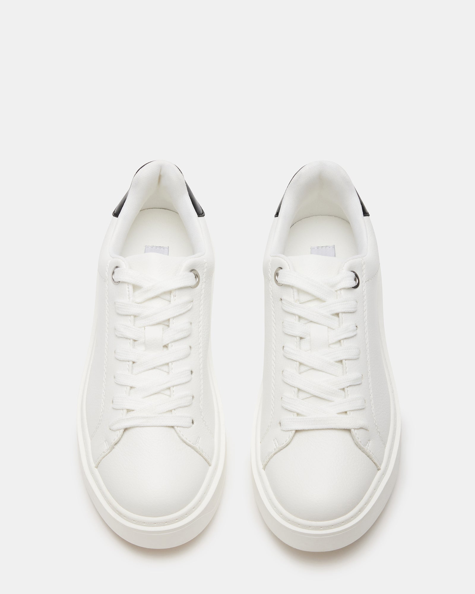 Side view of white sneakers with black accents on wooden bench