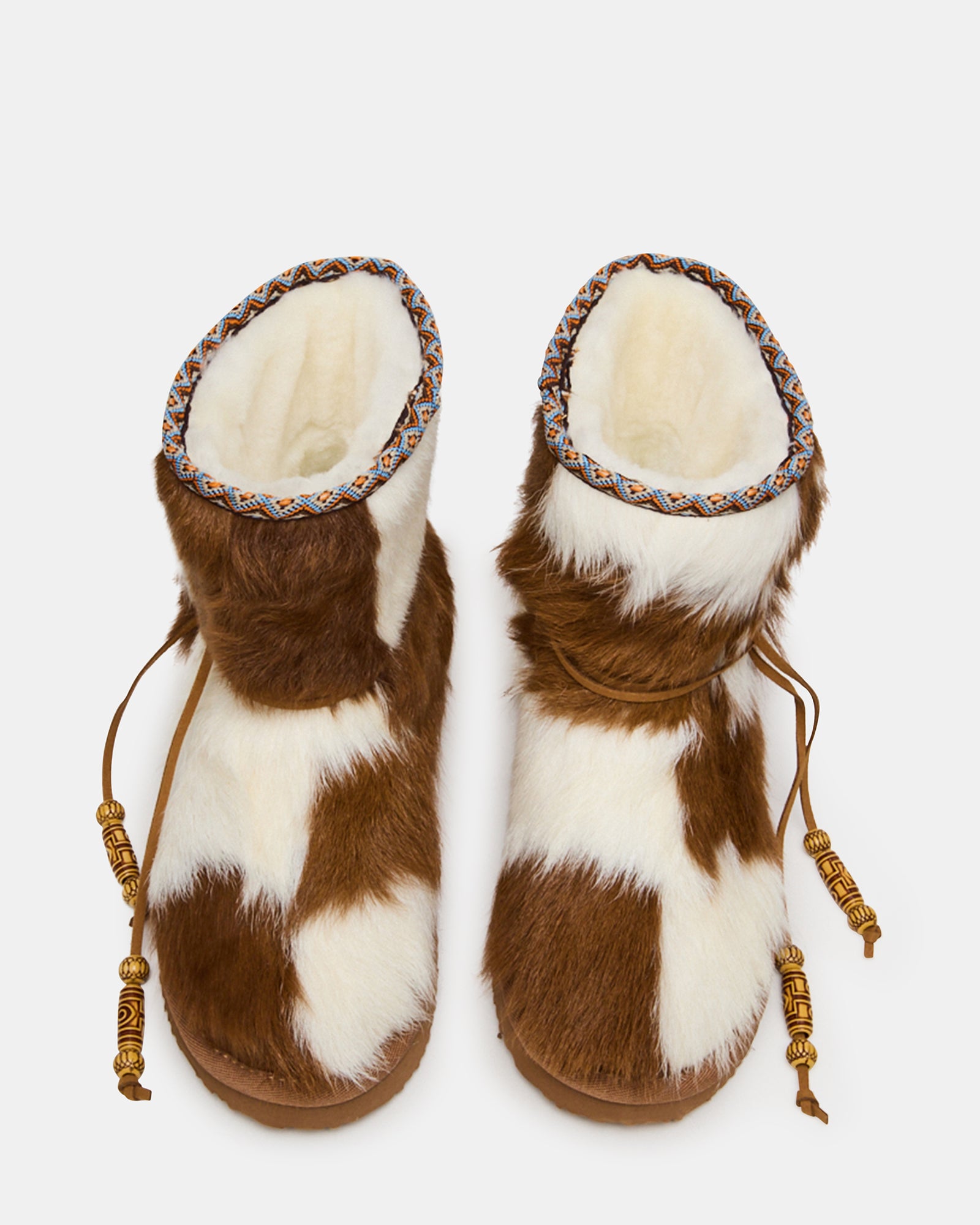 Side profile of womens ankle boots with faux fur cow print design