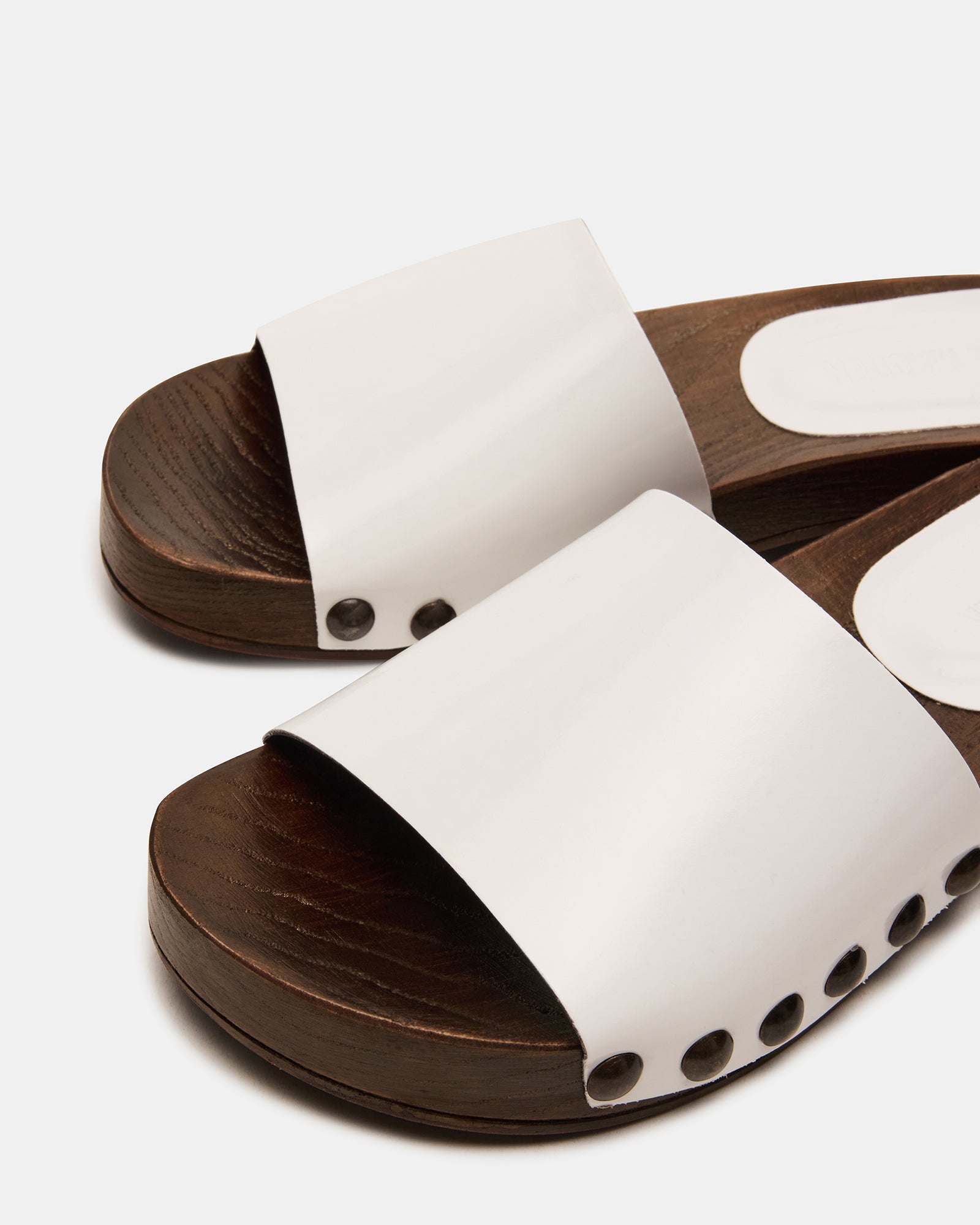 Side profile showcasing the 1.25-inch heel of the white patent sandals