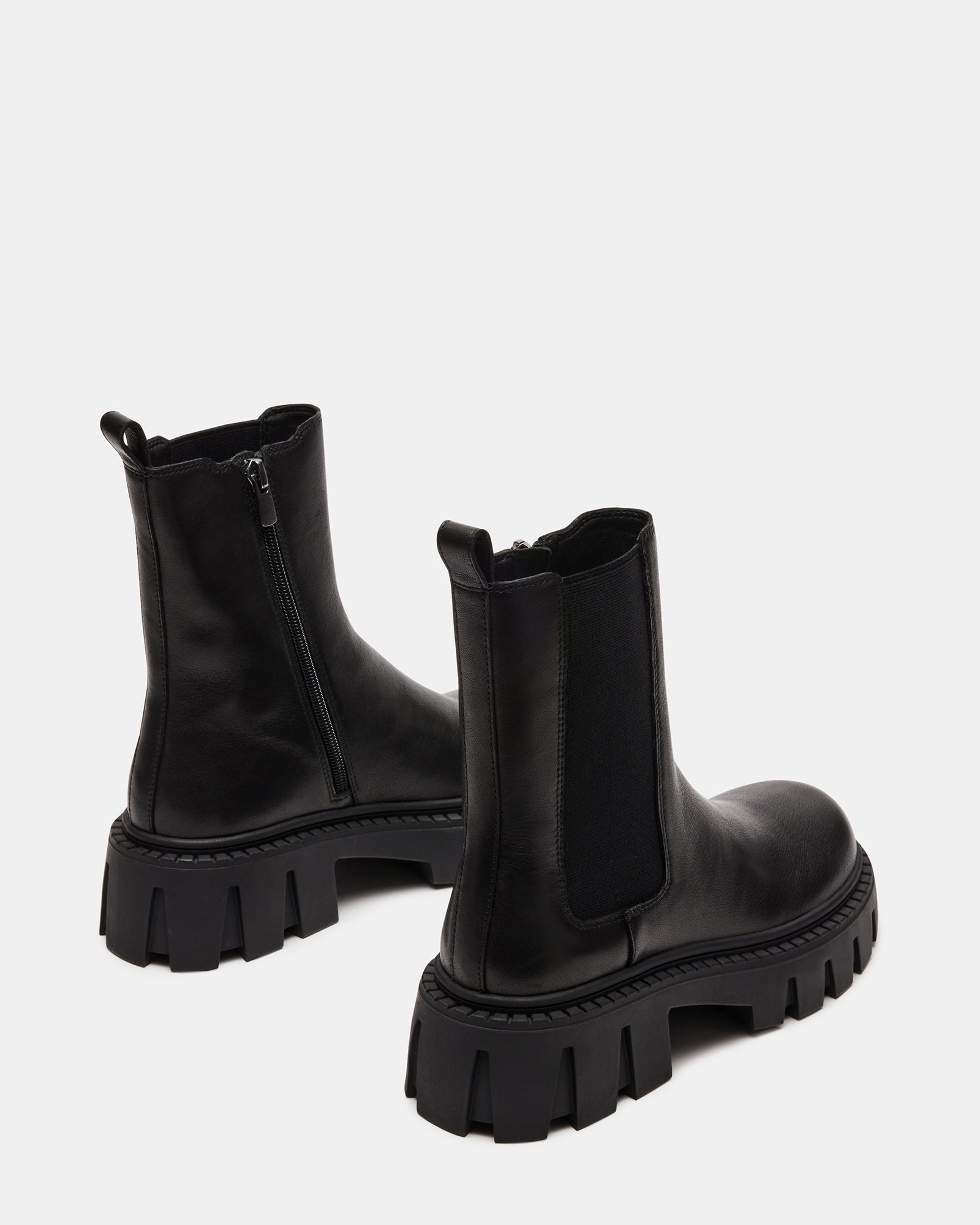 Black leather Chelsea boots paired with casual outfit for a city stroll.