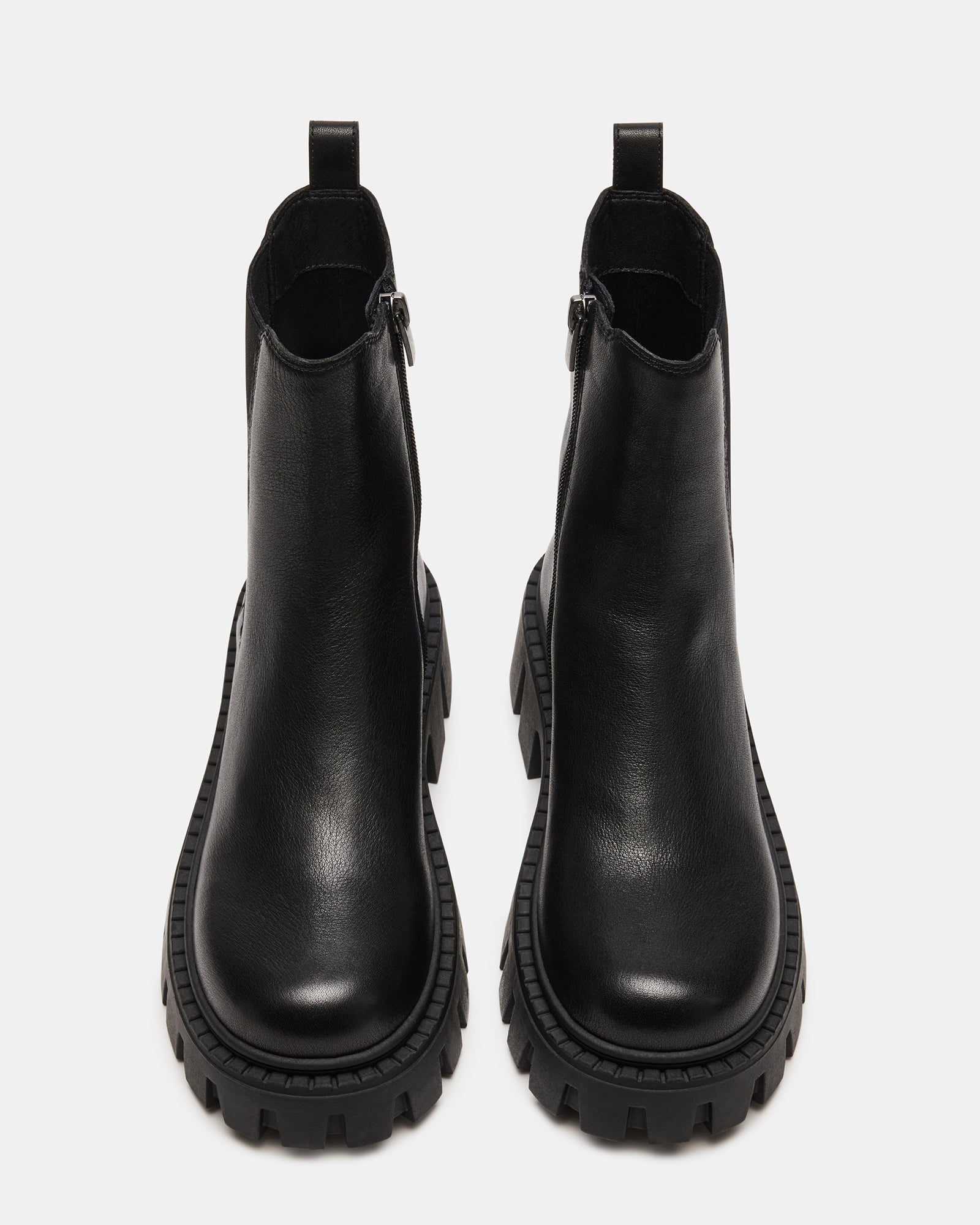 Close-up of the chunky lug sole on black leather Chelsea boots.