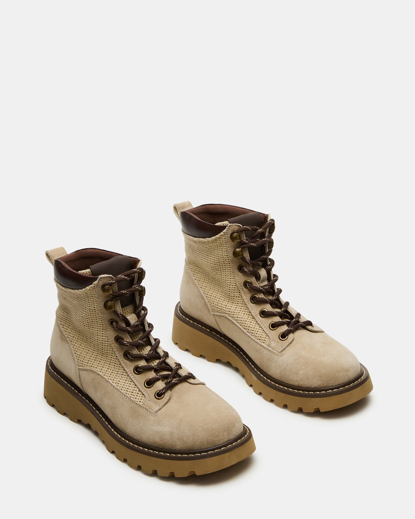 Close-up of lace up boots eyelets and soft textile lining against wood flooring