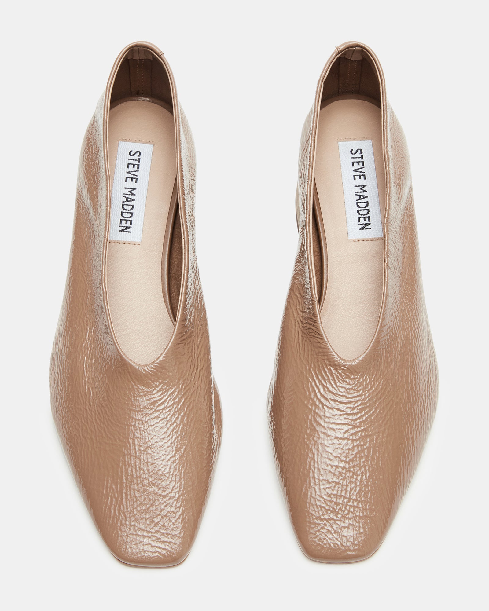 Overhead view of womens shoes with square toe design on a textured rug
