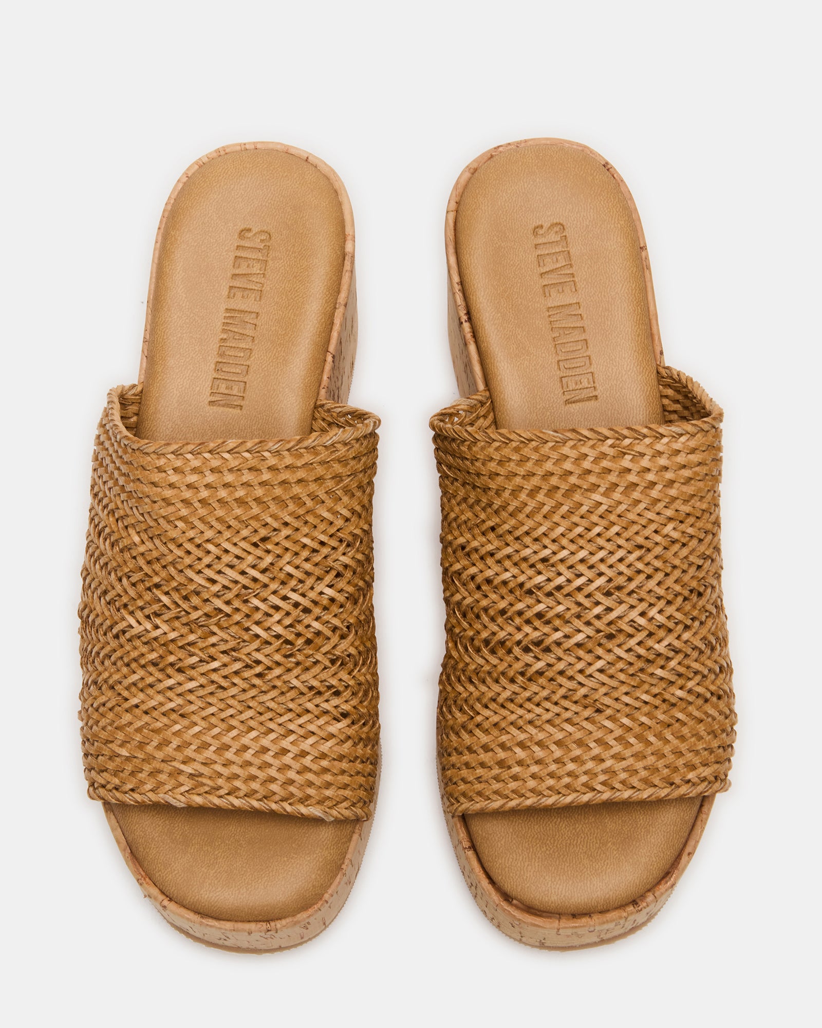 Coastal raffia wedge mule sandals displayed on a beach