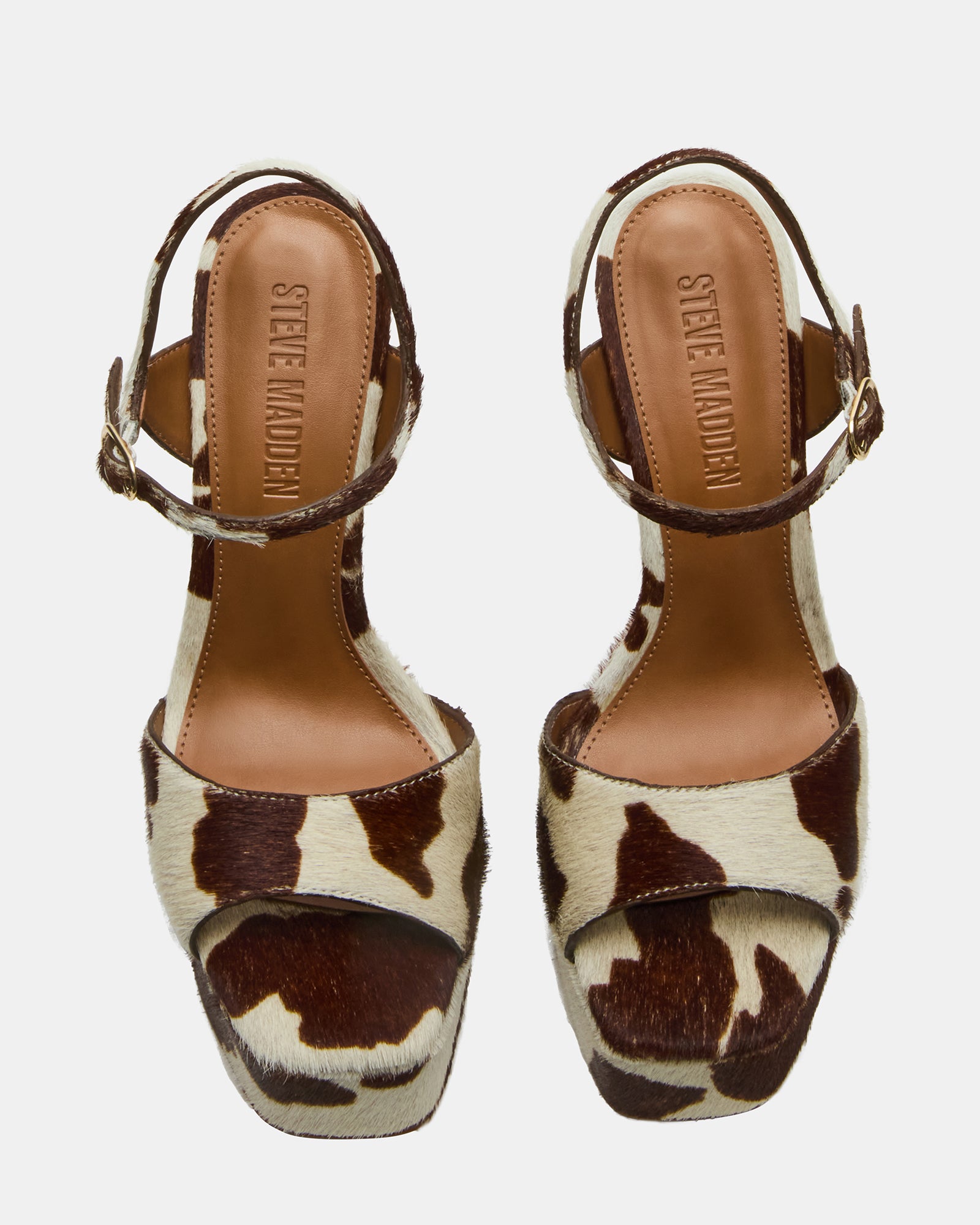 Side view of cow print stiletto heels with leather upper and high heel design