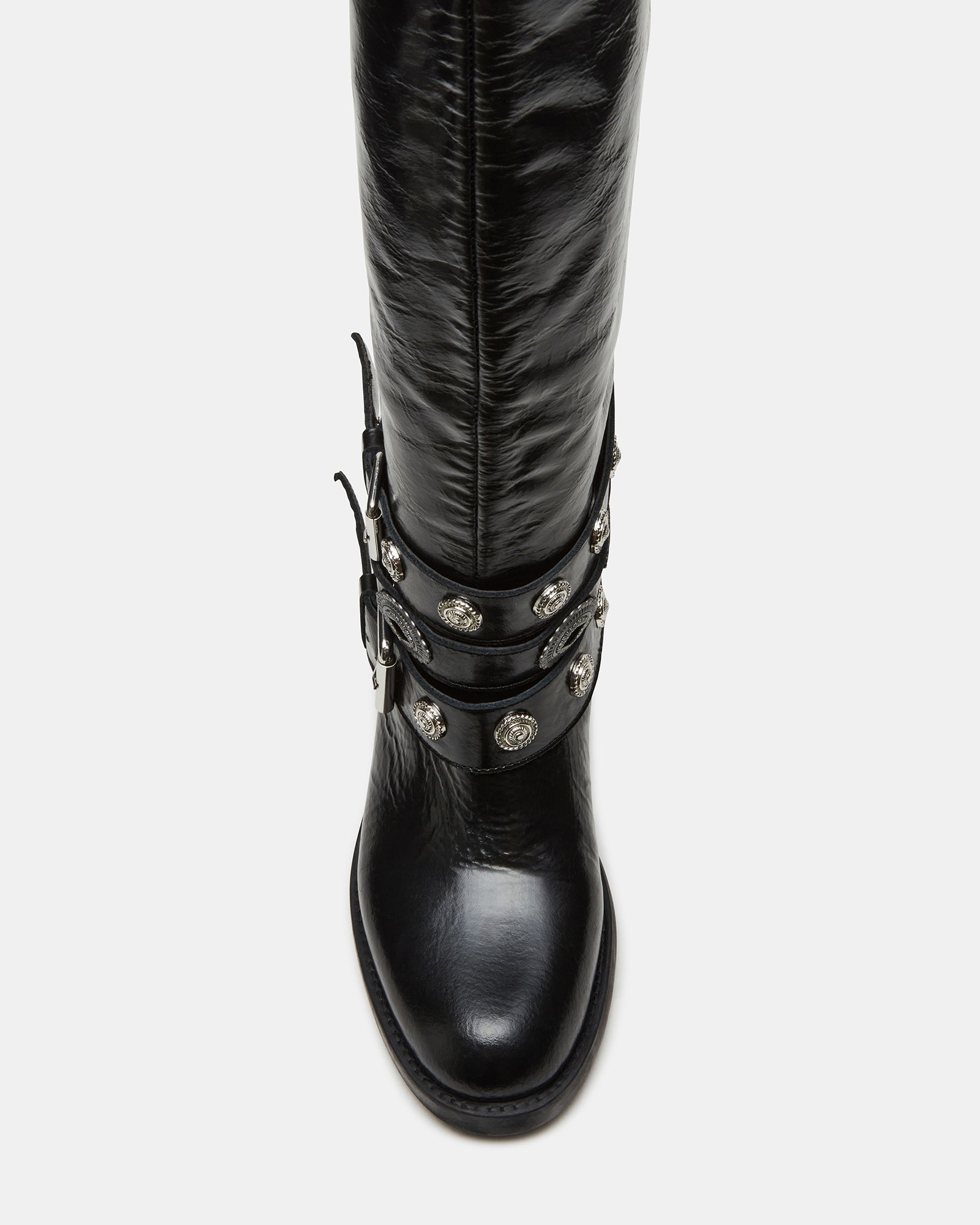 Side view of Steve Madden black leather moto boots showcasing buckle details.