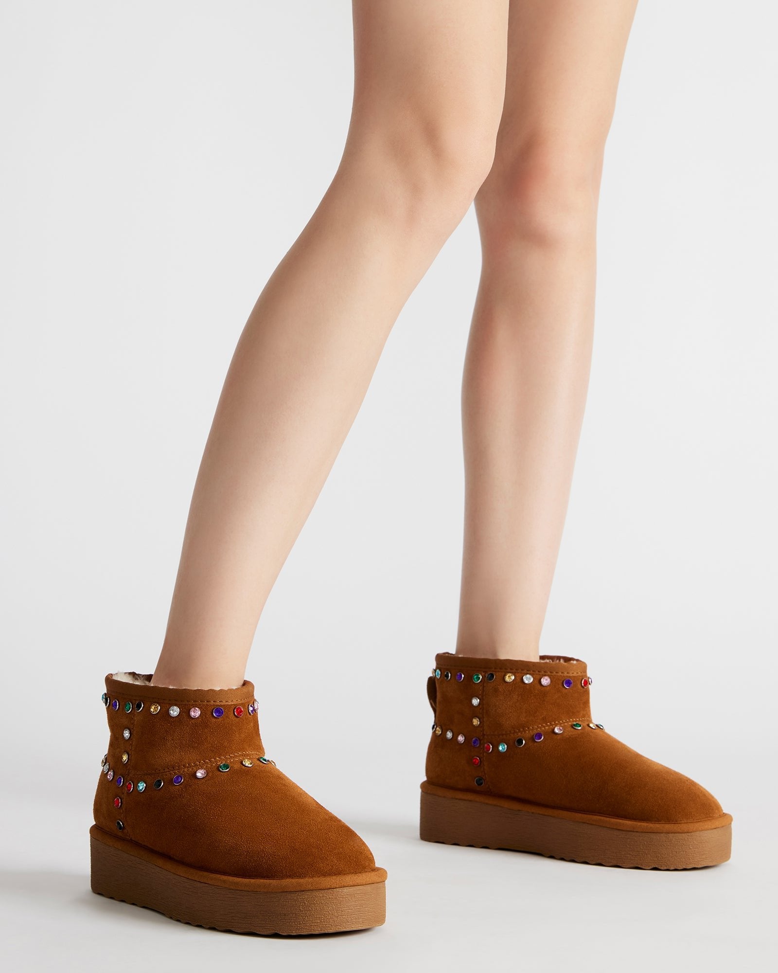 Close-up of rhinestone booties showing suede texture and embellishments