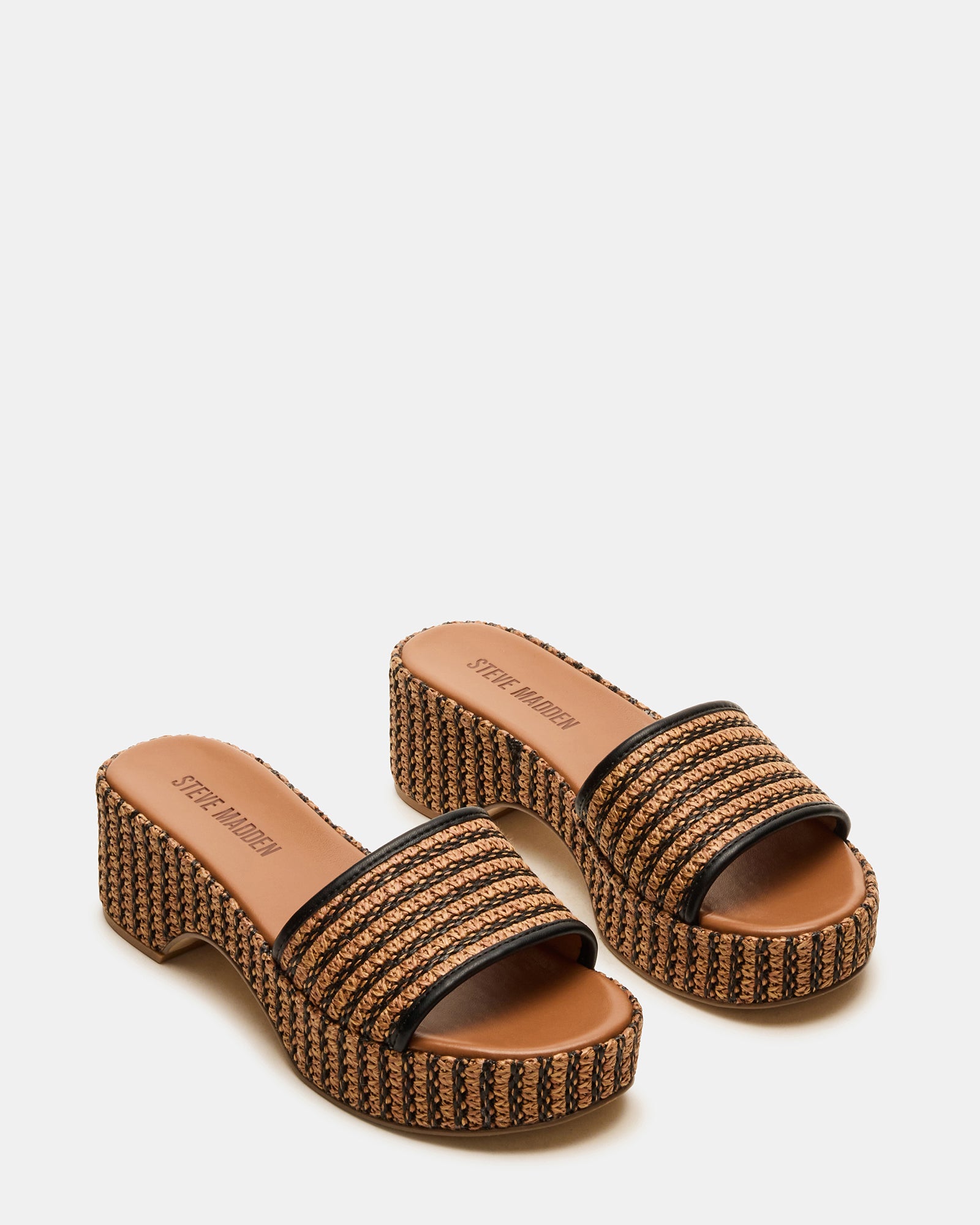 Cosima slide sandals worn by model walking on beachfront boardwalk
