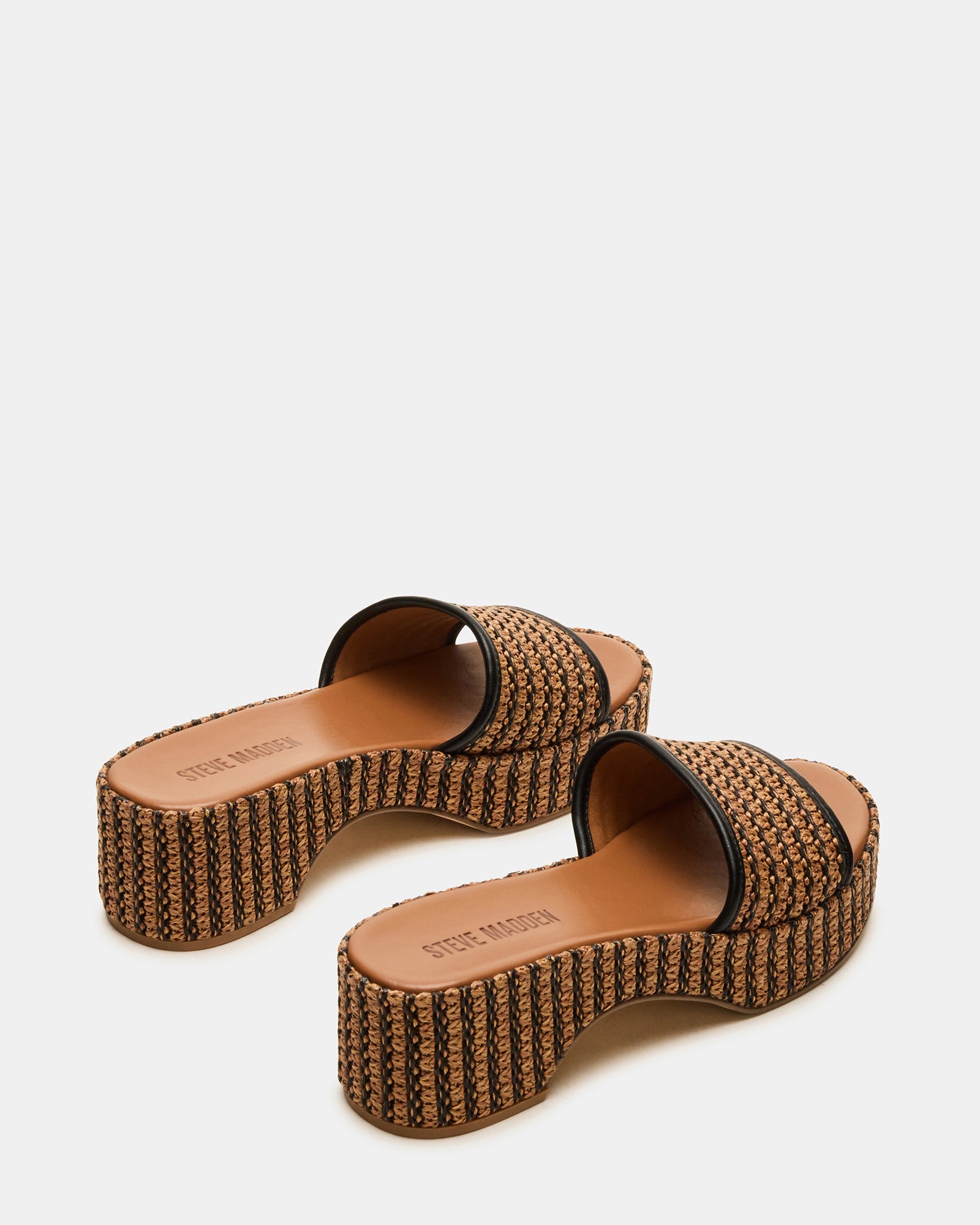 Cosima slide sandals worn by model walking on beachfront boardwalk