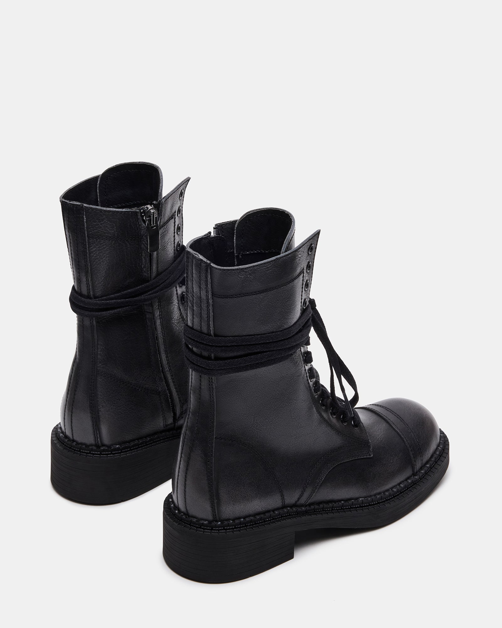 Close-up of the synthetic sole of the black combat boots, emphasizing durability.