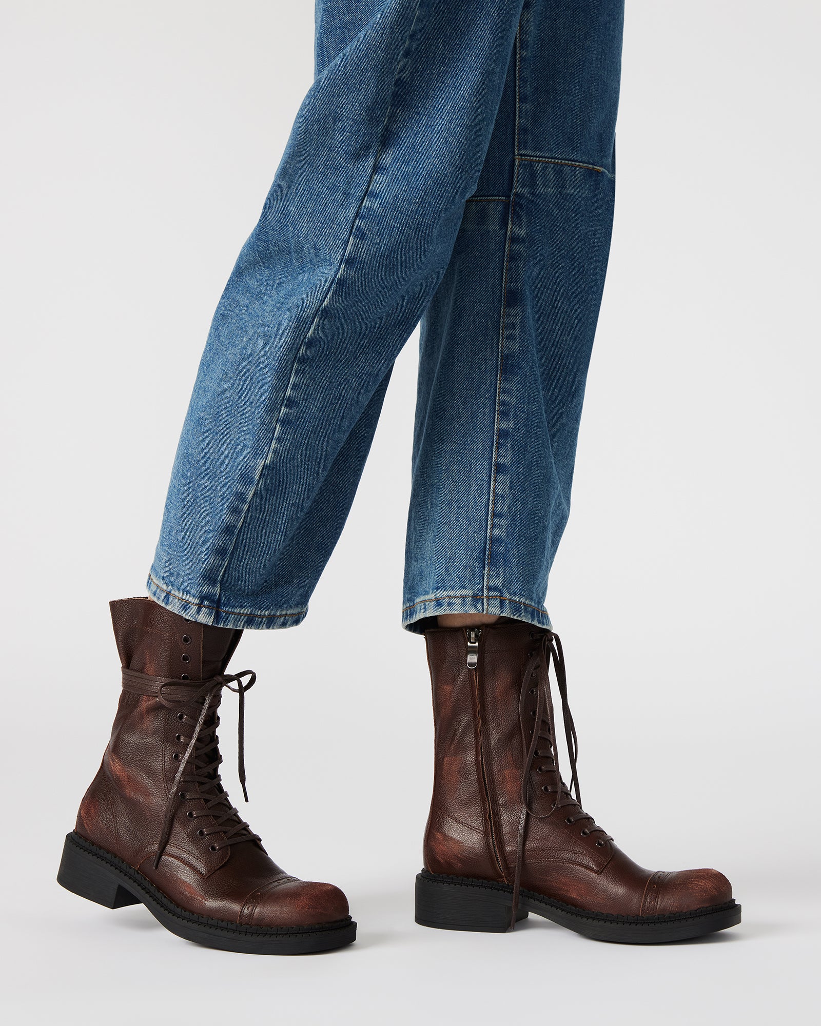 Front angle of lace-up womens combat boots on a wooden floor