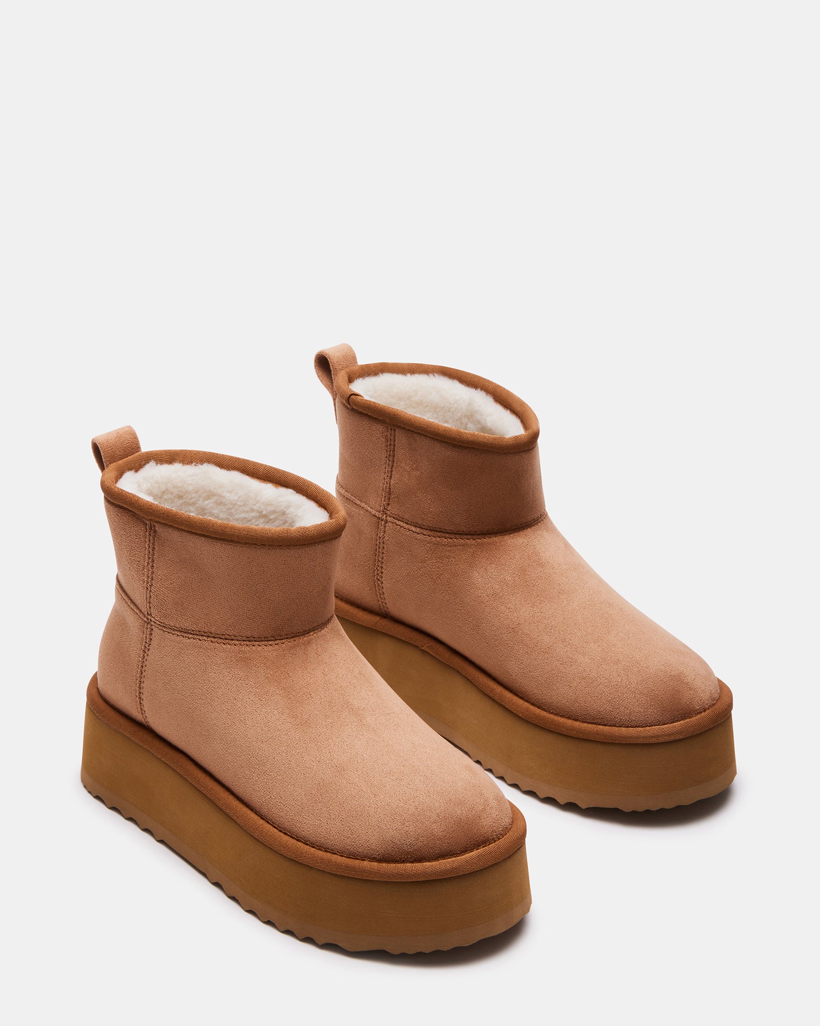 Close-up of black platform booties highlighting the slip-on design and faux shearling interior.