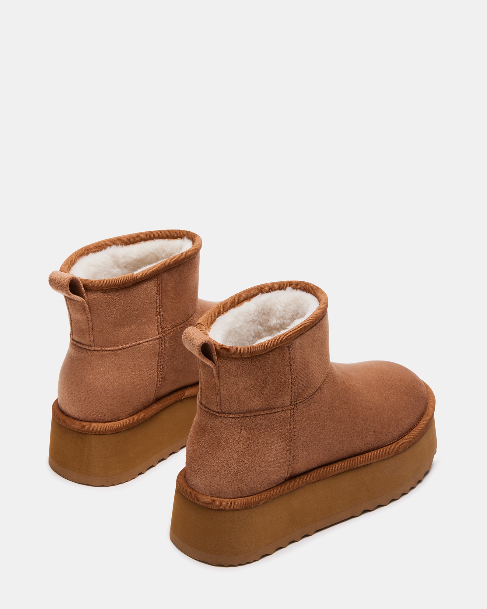 Close-up of black platform booties highlighting the slip-on design and faux shearling interior.