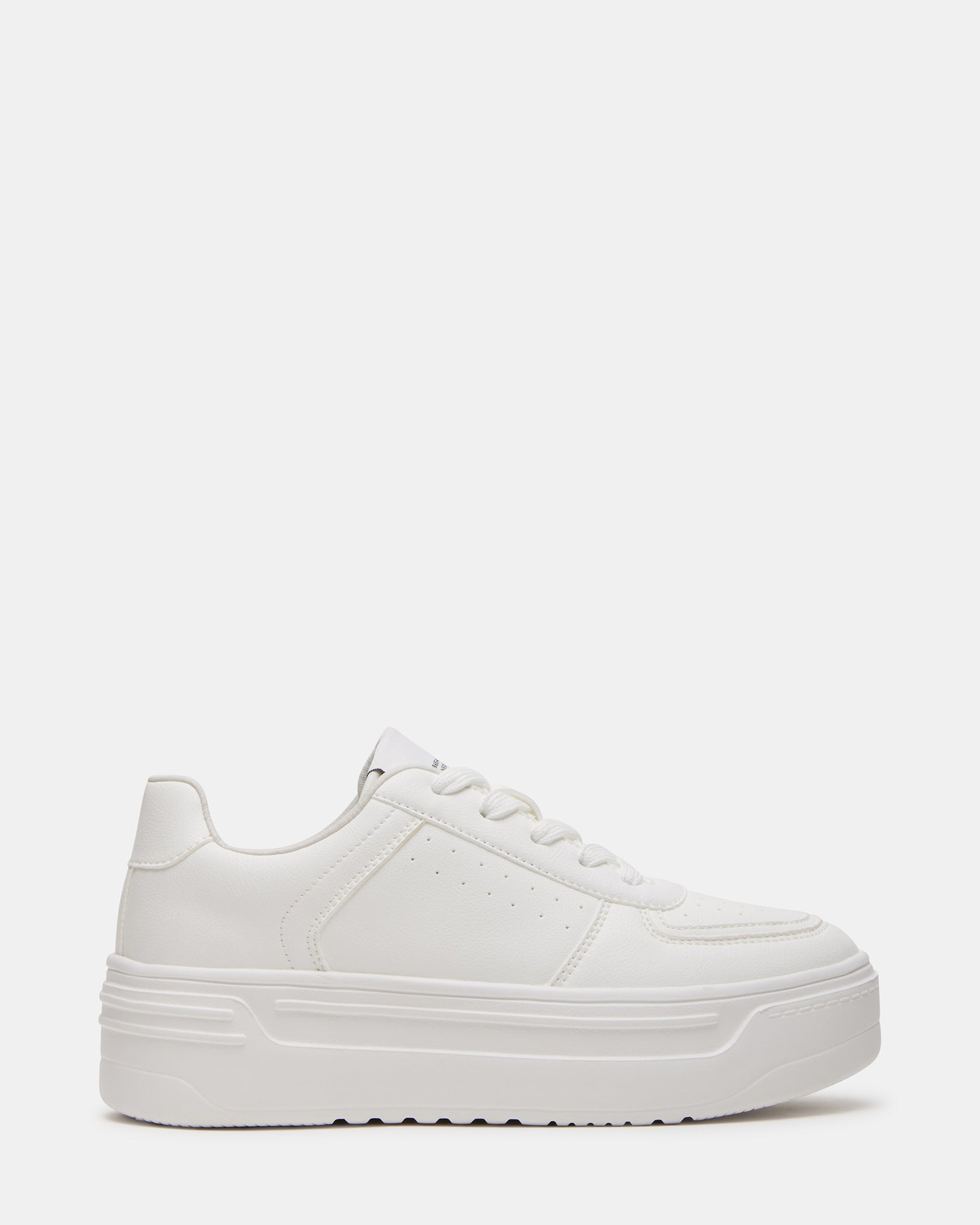 Side profile of women's white platform sneakers on cobblestone street