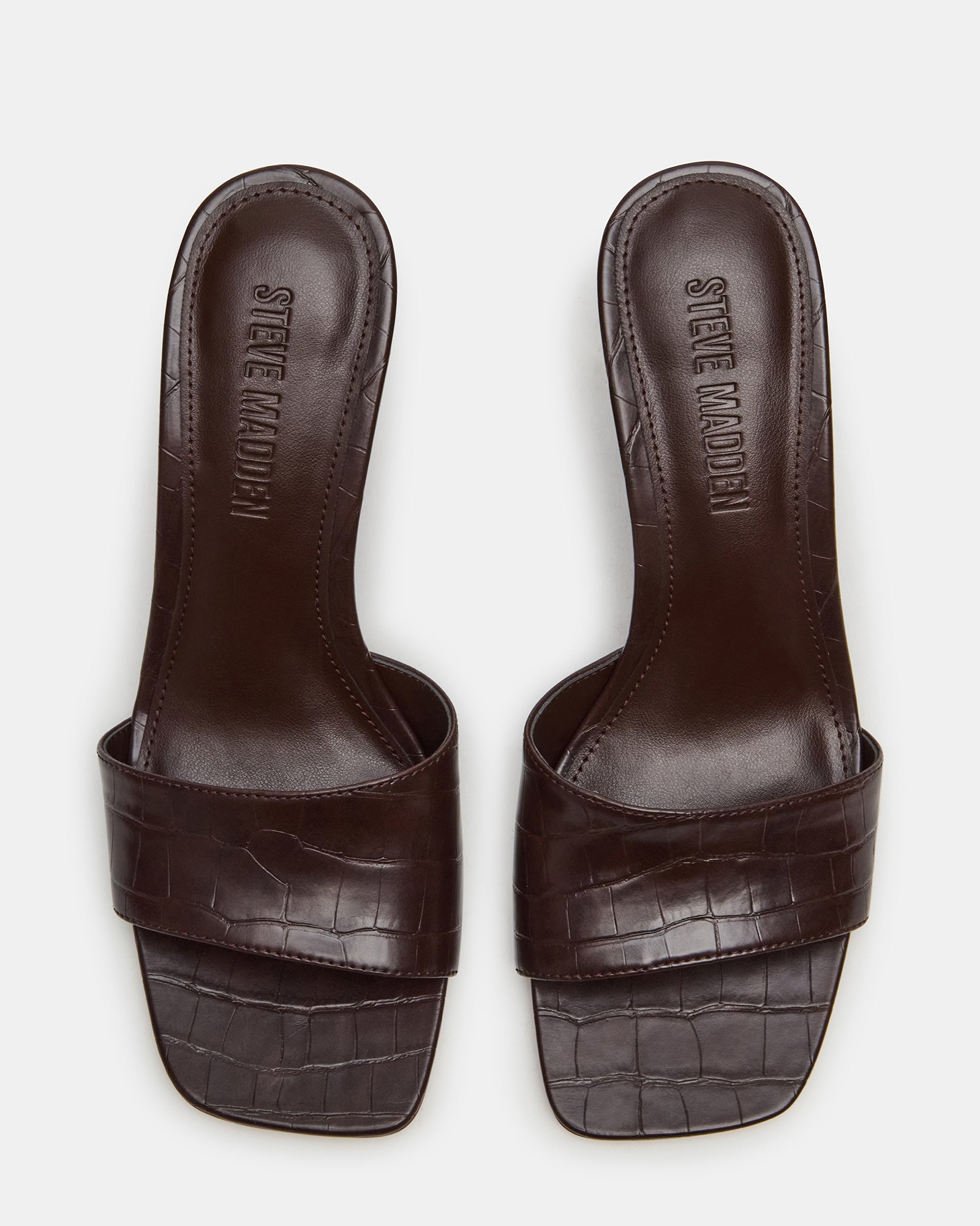 Crocodile square toe heeled sandals on a stylish surface.