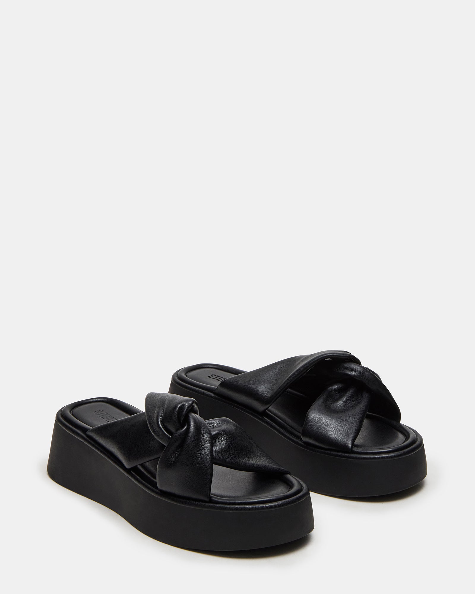 Black platform sandals worn casually outdoors, perfect for summer outings.
