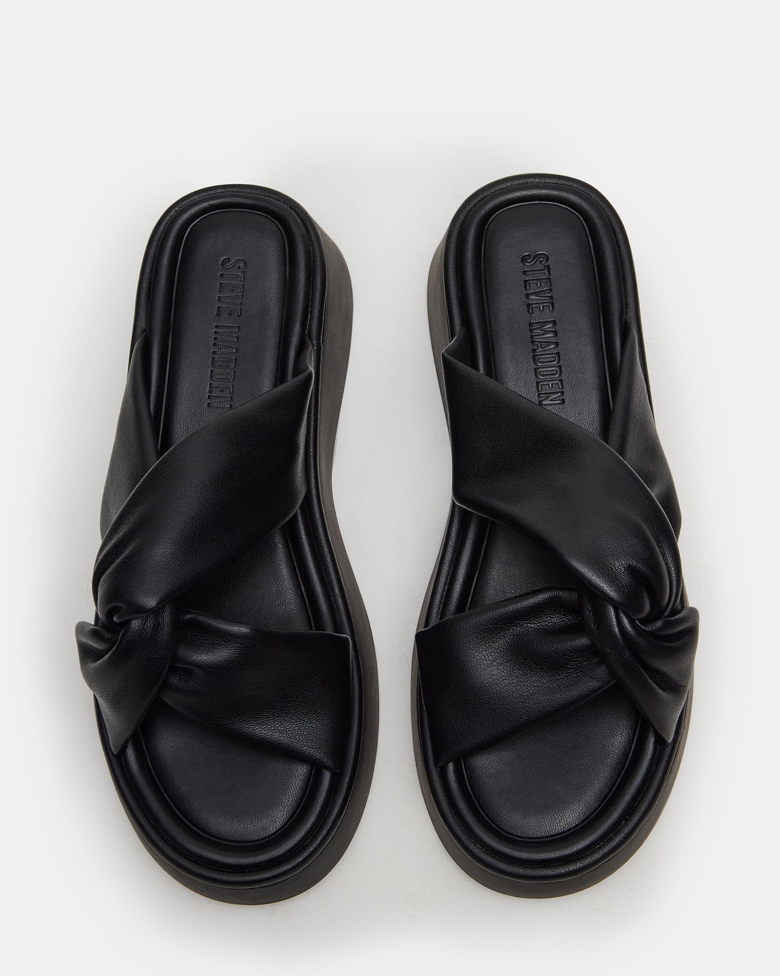 Close-up of black platform sandals highlighting the knot detail and vegan leather.