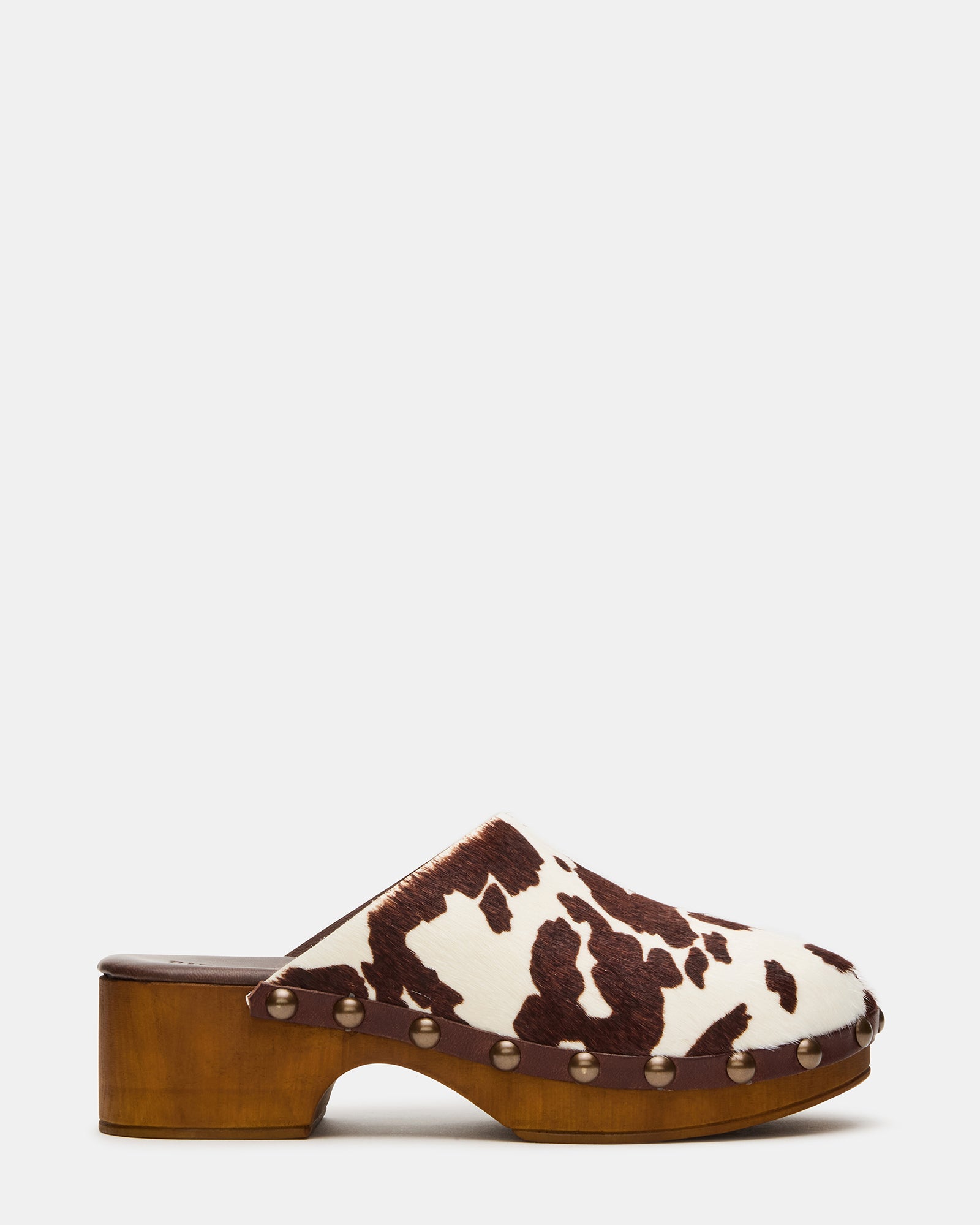 Close-up of studded mule clogs showing textured cowhide pattern and leather finish