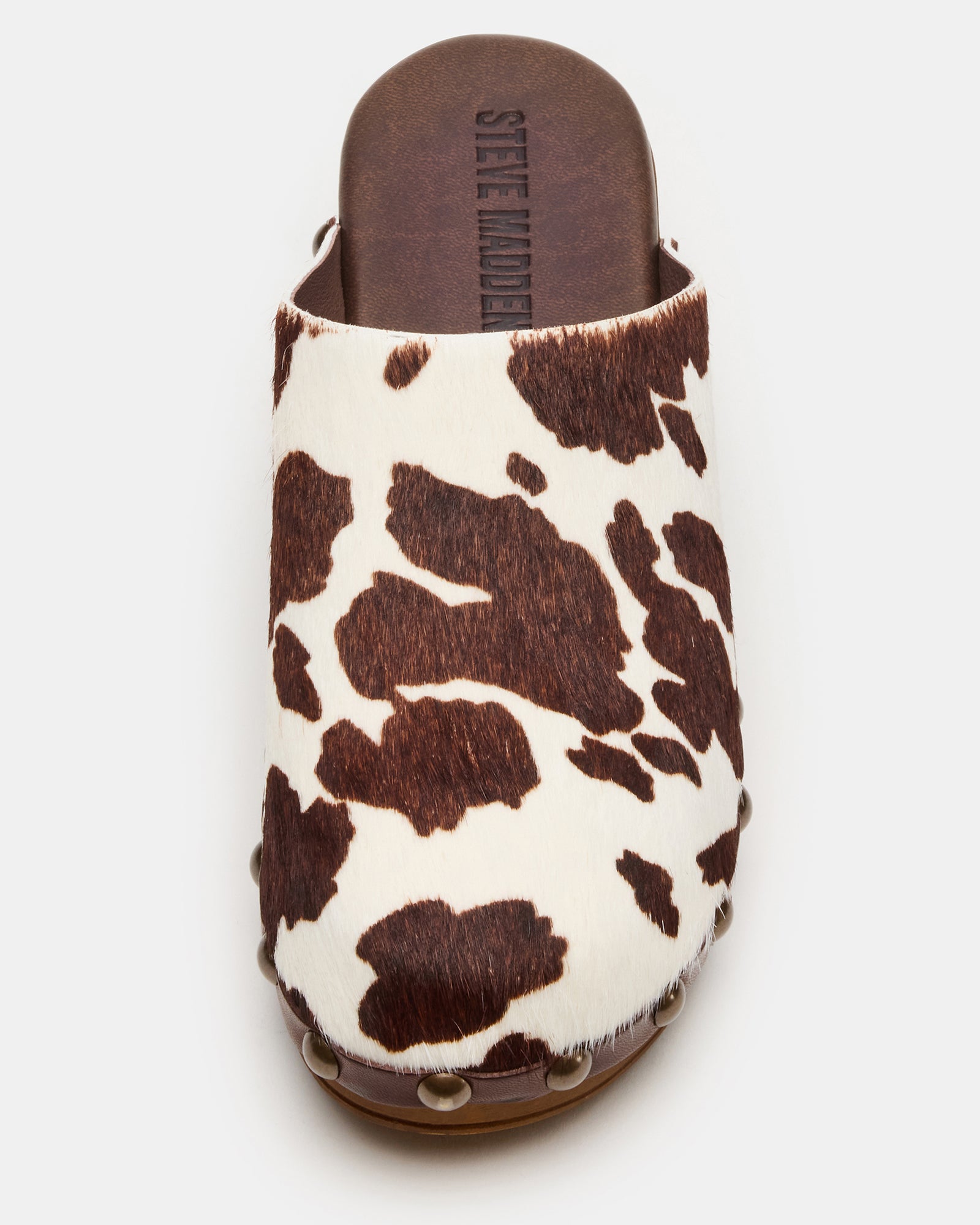 Close-up of studded mule clogs showing textured cowhide pattern and leather finish