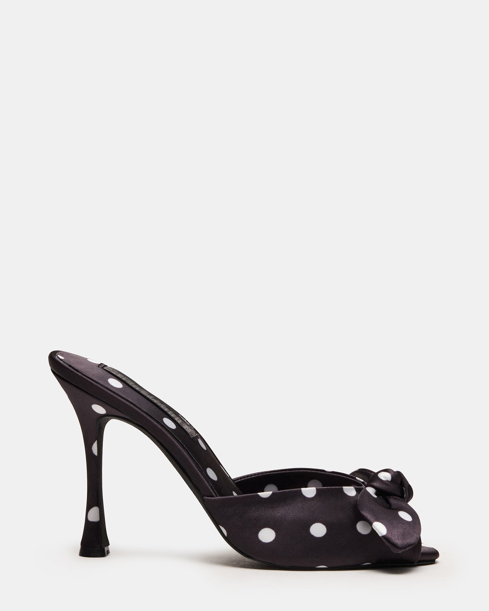 Elegant black and white mules showcasing a playful polka dot pattern.