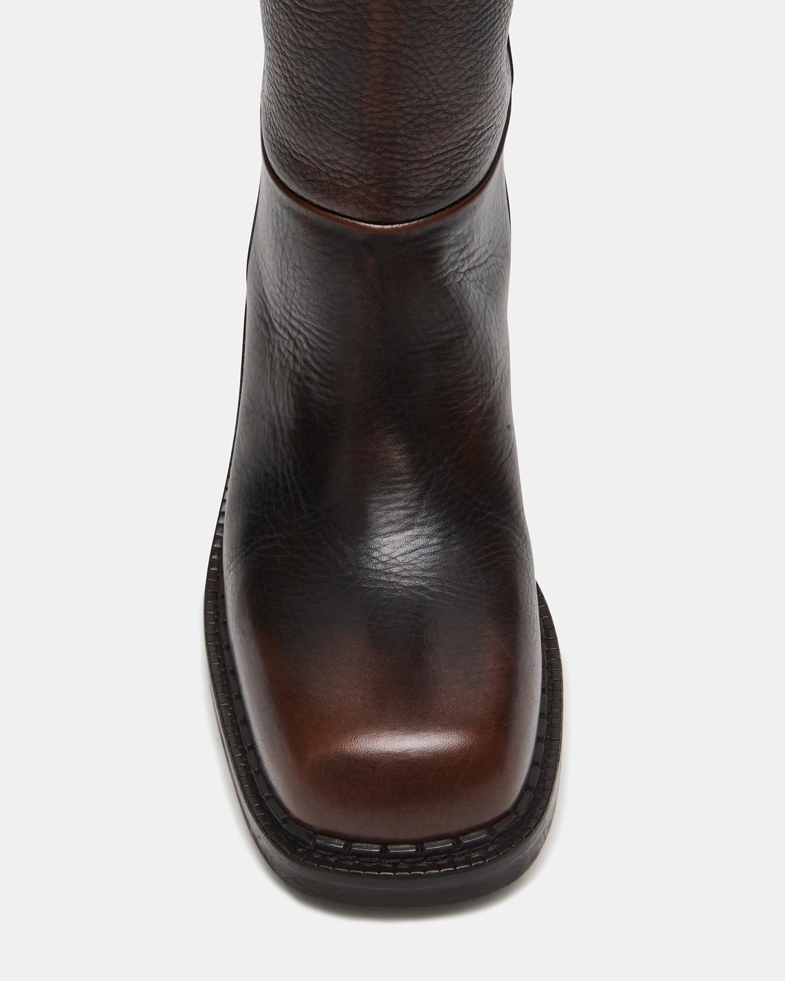 Side profile of brown knee high boots showing square toe and heel height