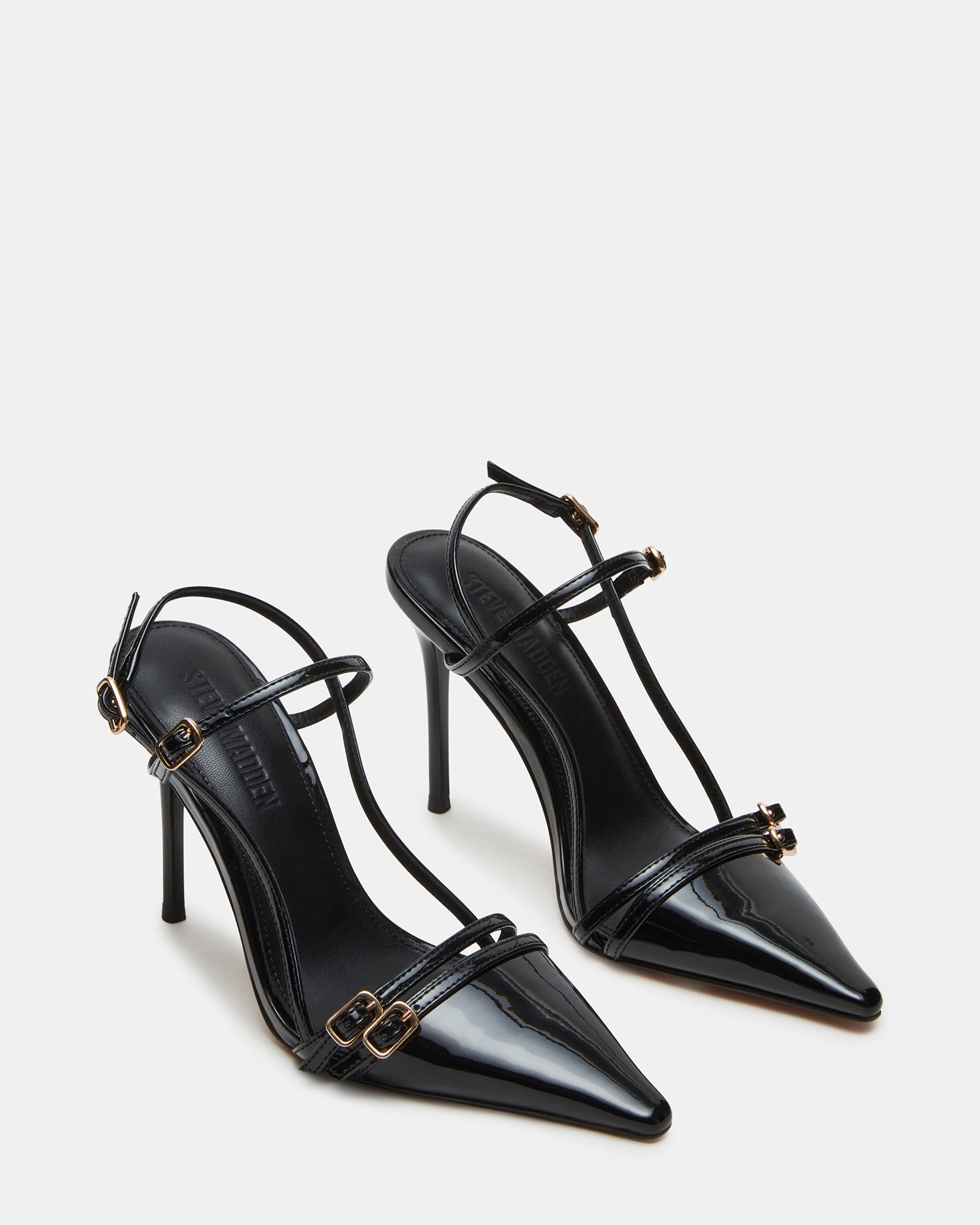 Model wearing black patent leather heels with a fitted dress for a night out