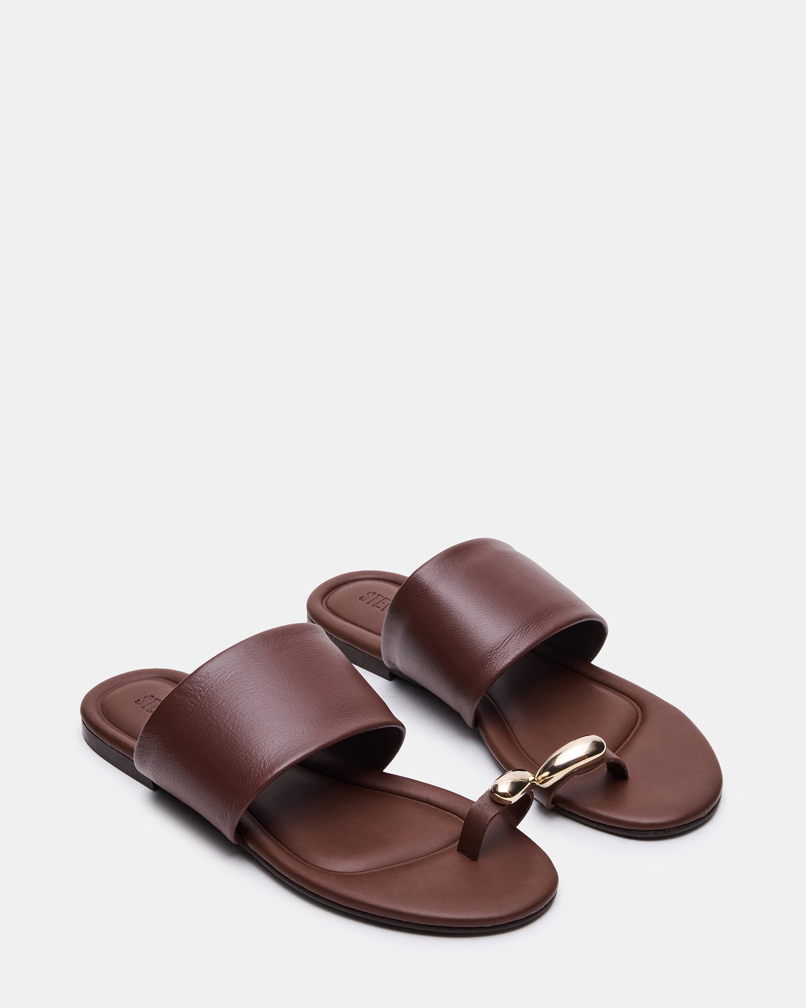 Side view of stylish leather slide sandals showing the flat sole and rounded toe