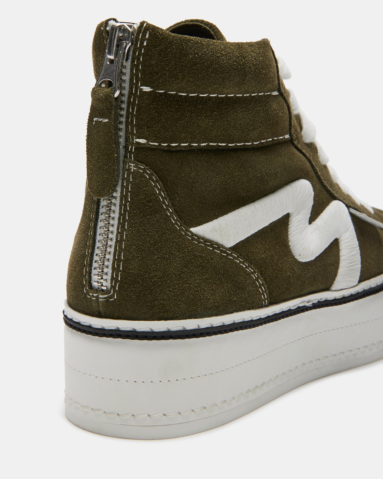 Close-up of the suede material and contrast stitching on the sneakers.