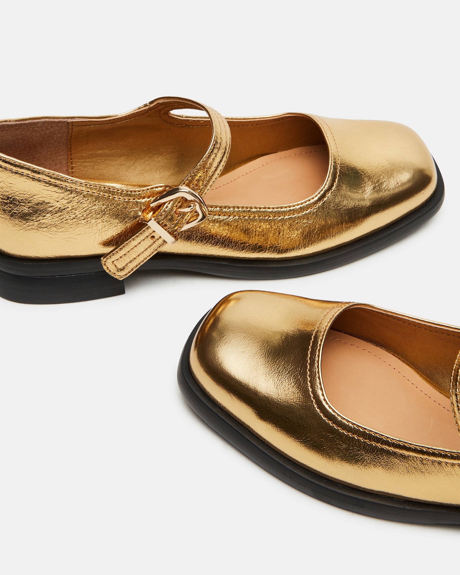 Top angle showing pumps Mary Jane shoes in gold beside a weekend travel tote.