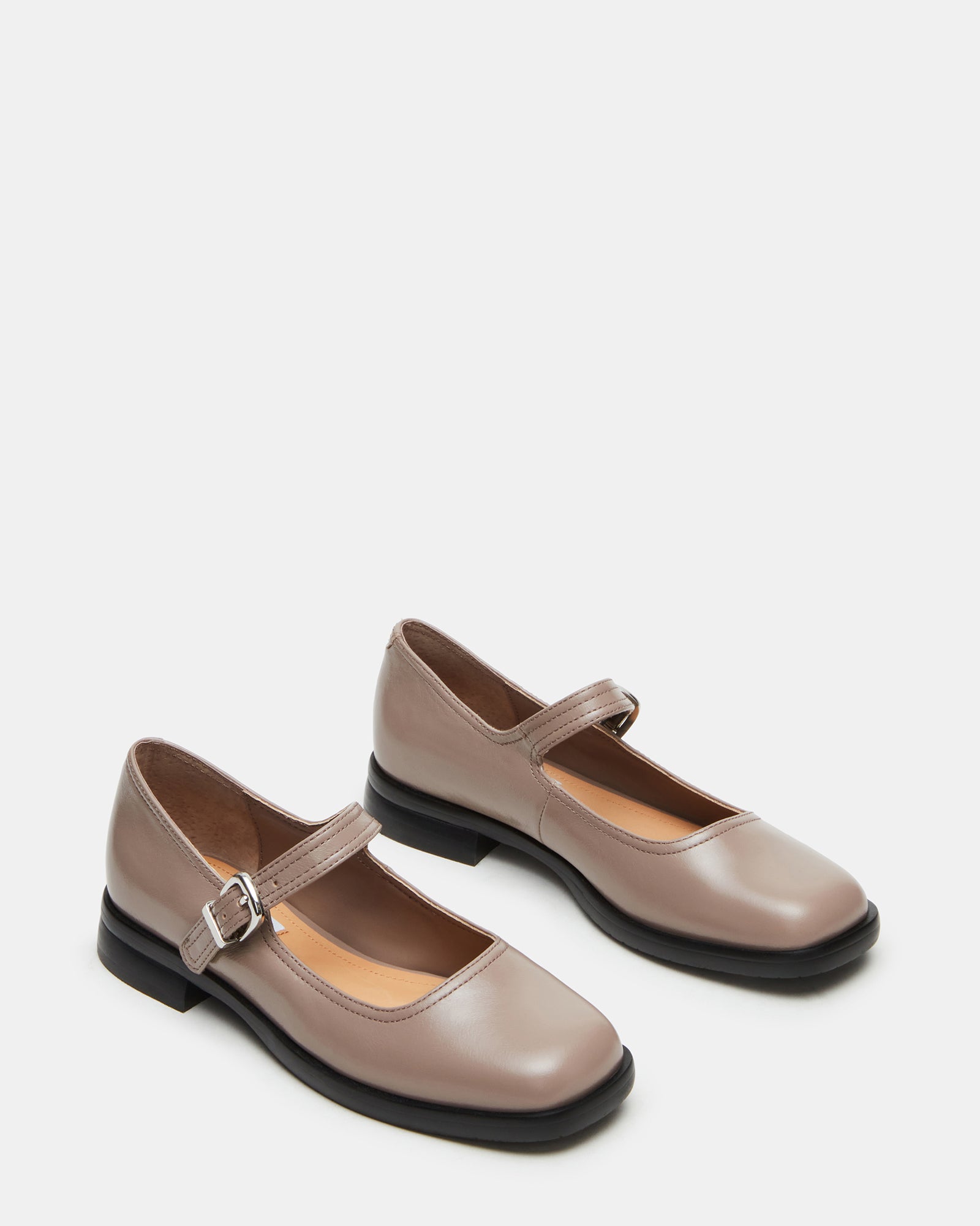 Woman wearing platform mary jane shoes while walking along Savannah cobblestones.