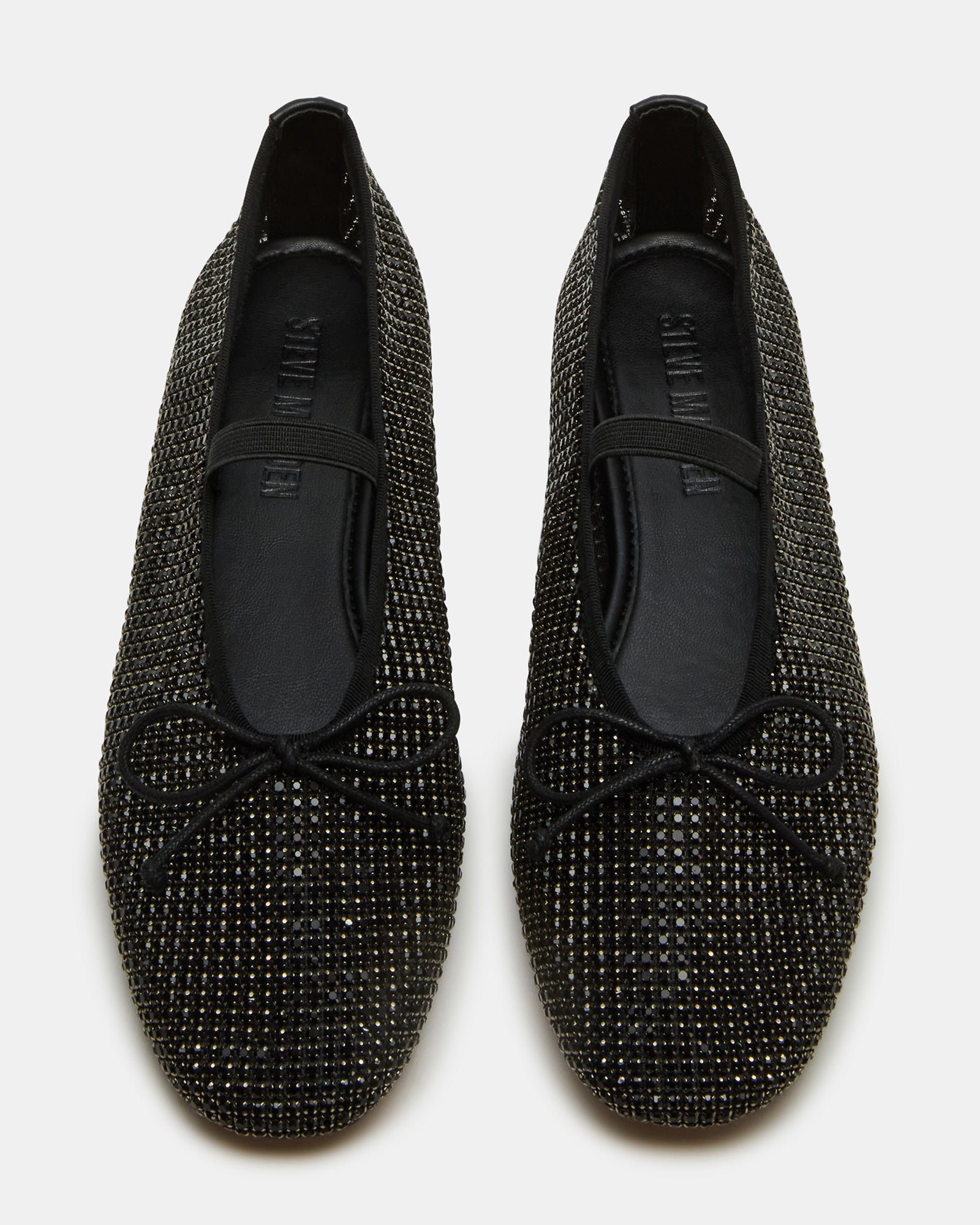 Close-up of black ballet flats with a bow and rhinestones