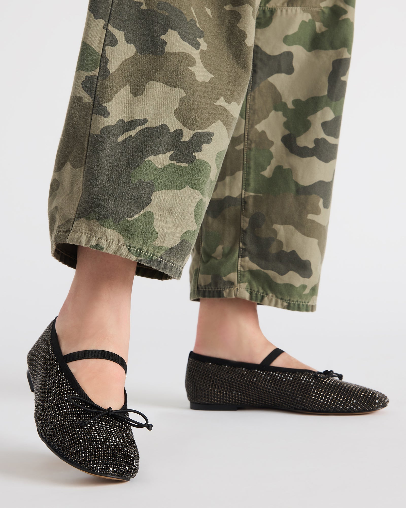 Close-up of black ballet flats with a bow and rhinestones