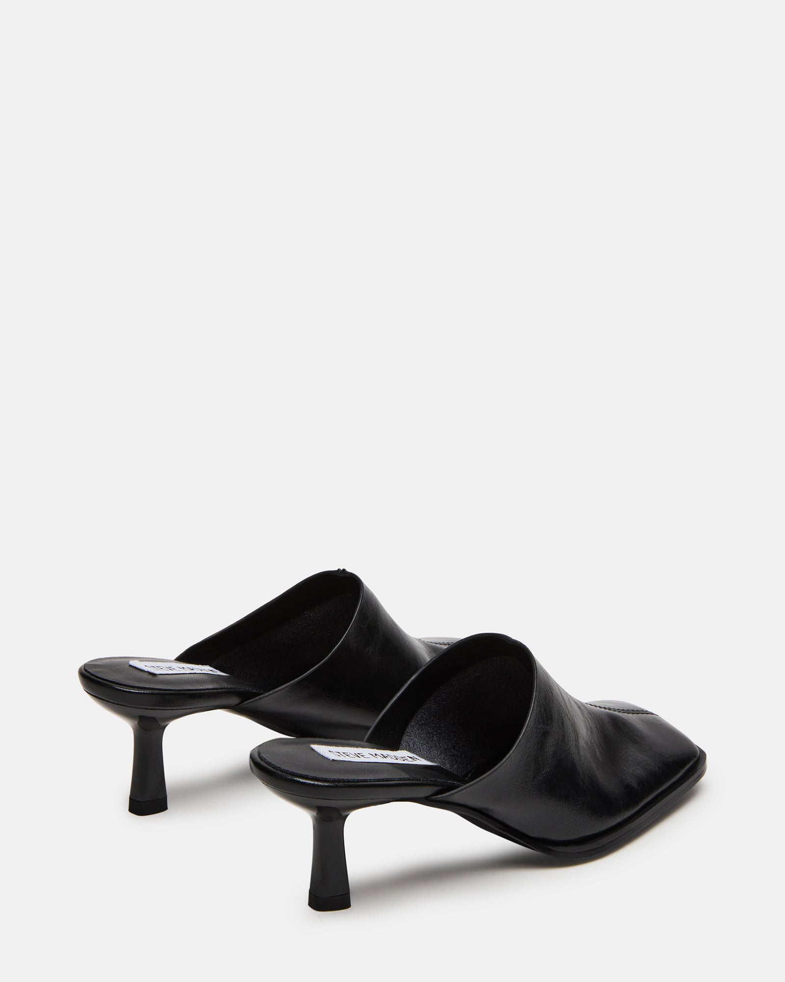 Model wearing Dempsey leather mules in urban setting
