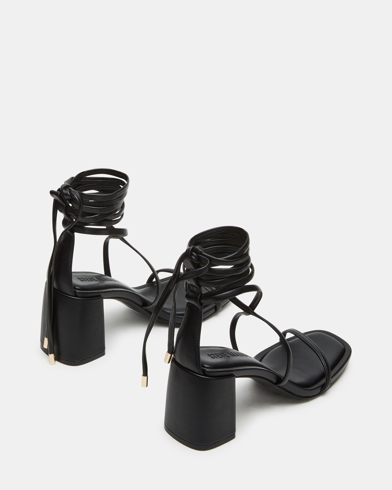 Black block high heel shoes styled with tailored trousers in an outdoor SoCal café setting