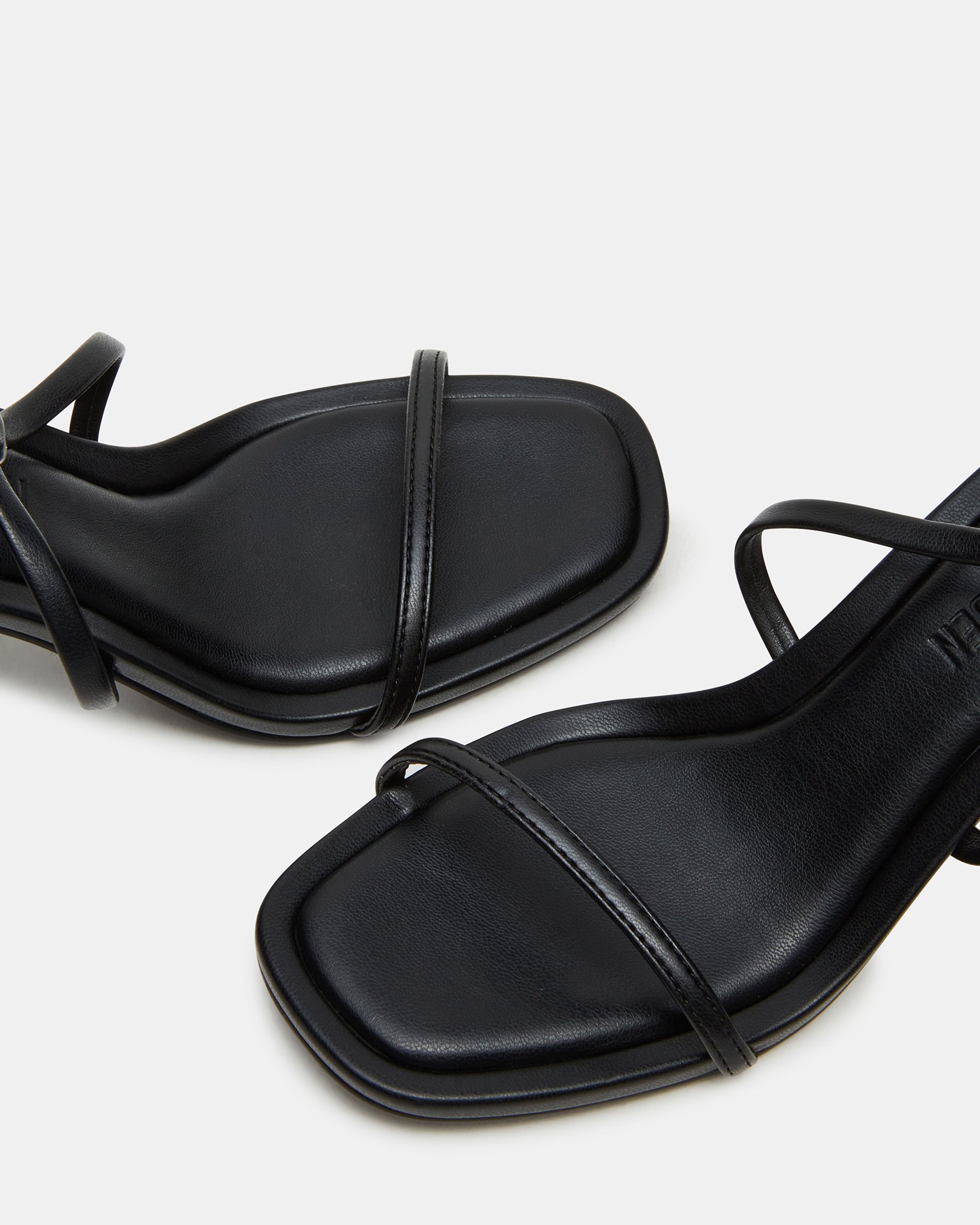 Close-up of vegan leather red strappy heels worn with a summer maxi dress