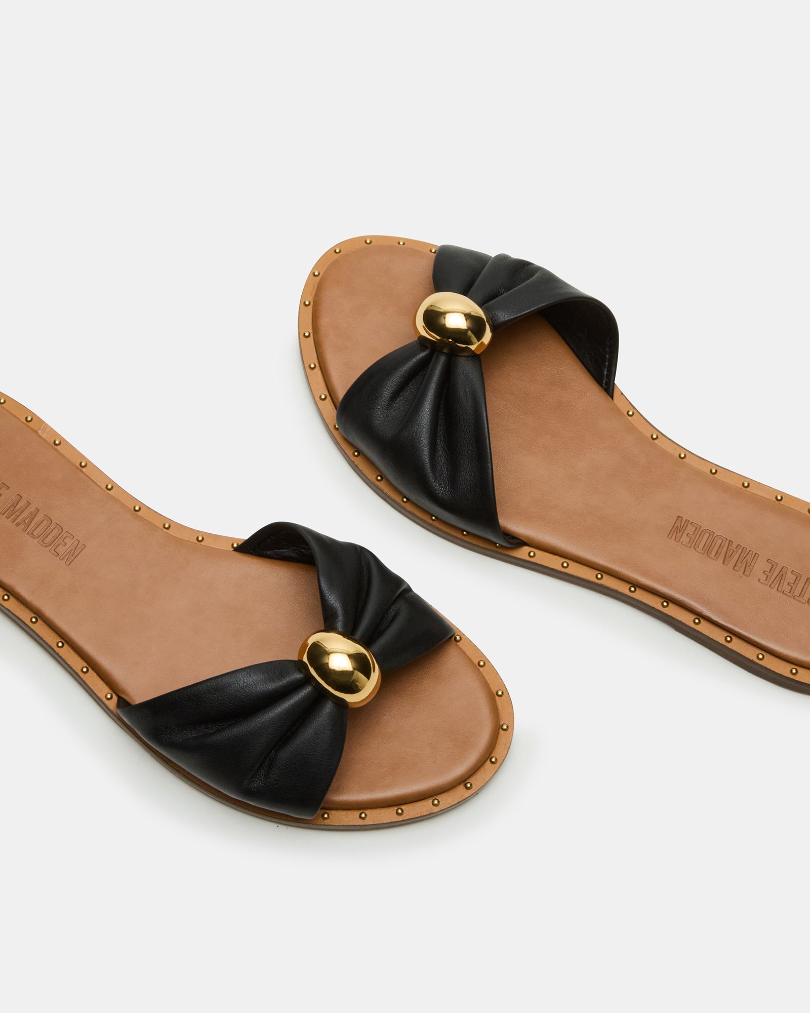 Close-up of Dipsy slide sandals highlighting stud details and leather texture.