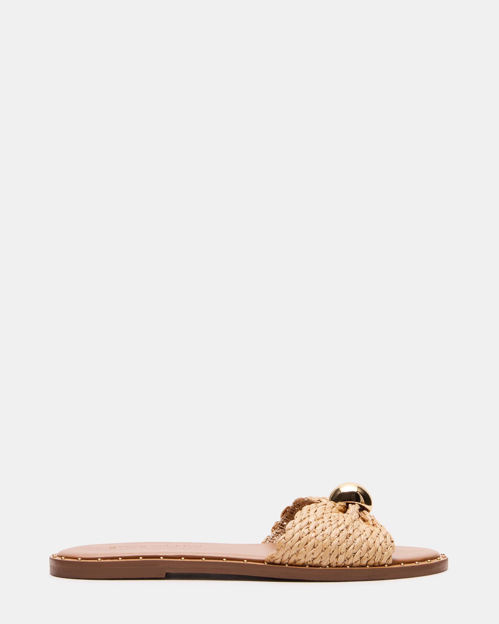 Side view of DIPSY raffia sandals in a garden setting.