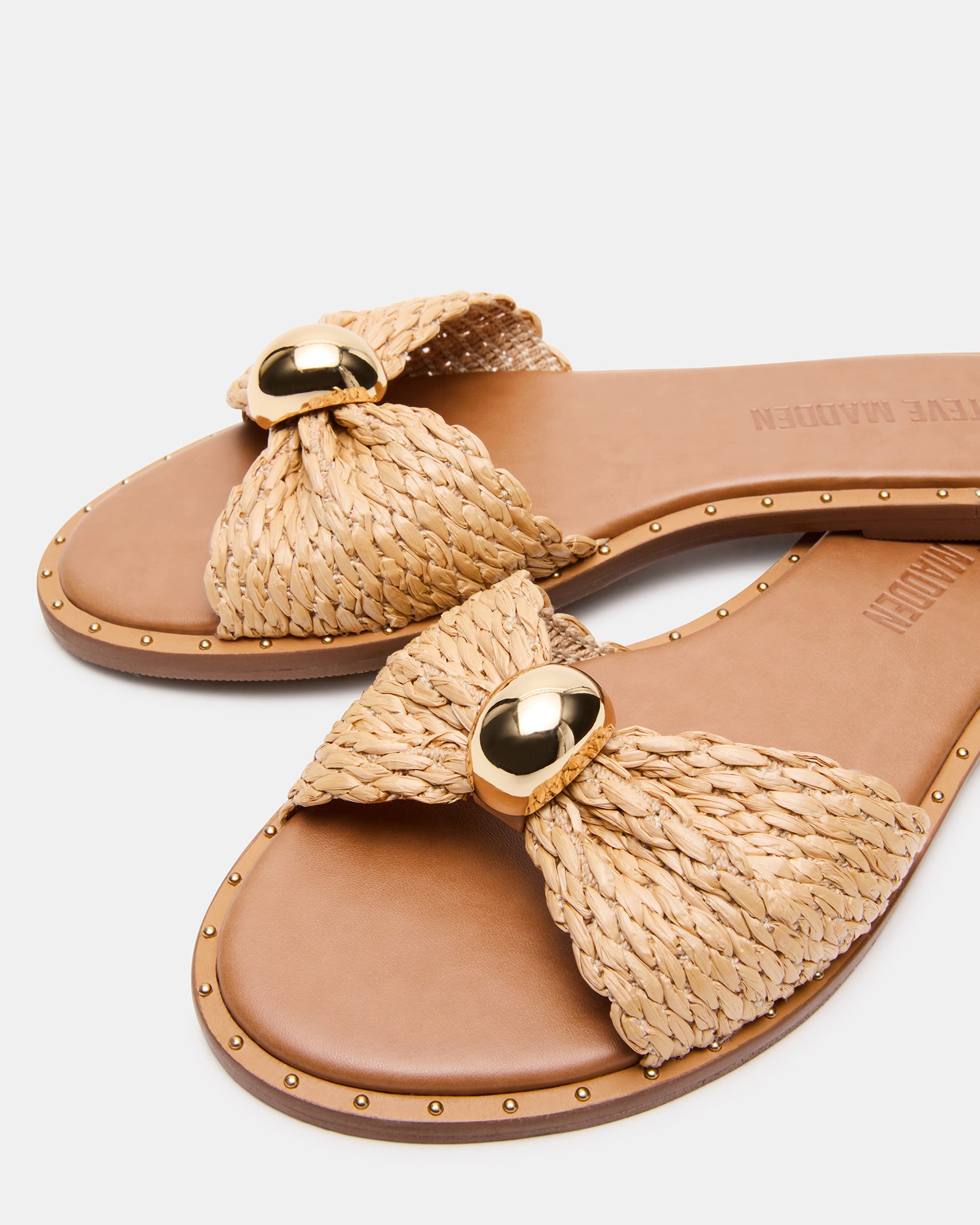 Side view of DIPSY raffia sandals in a garden setting.