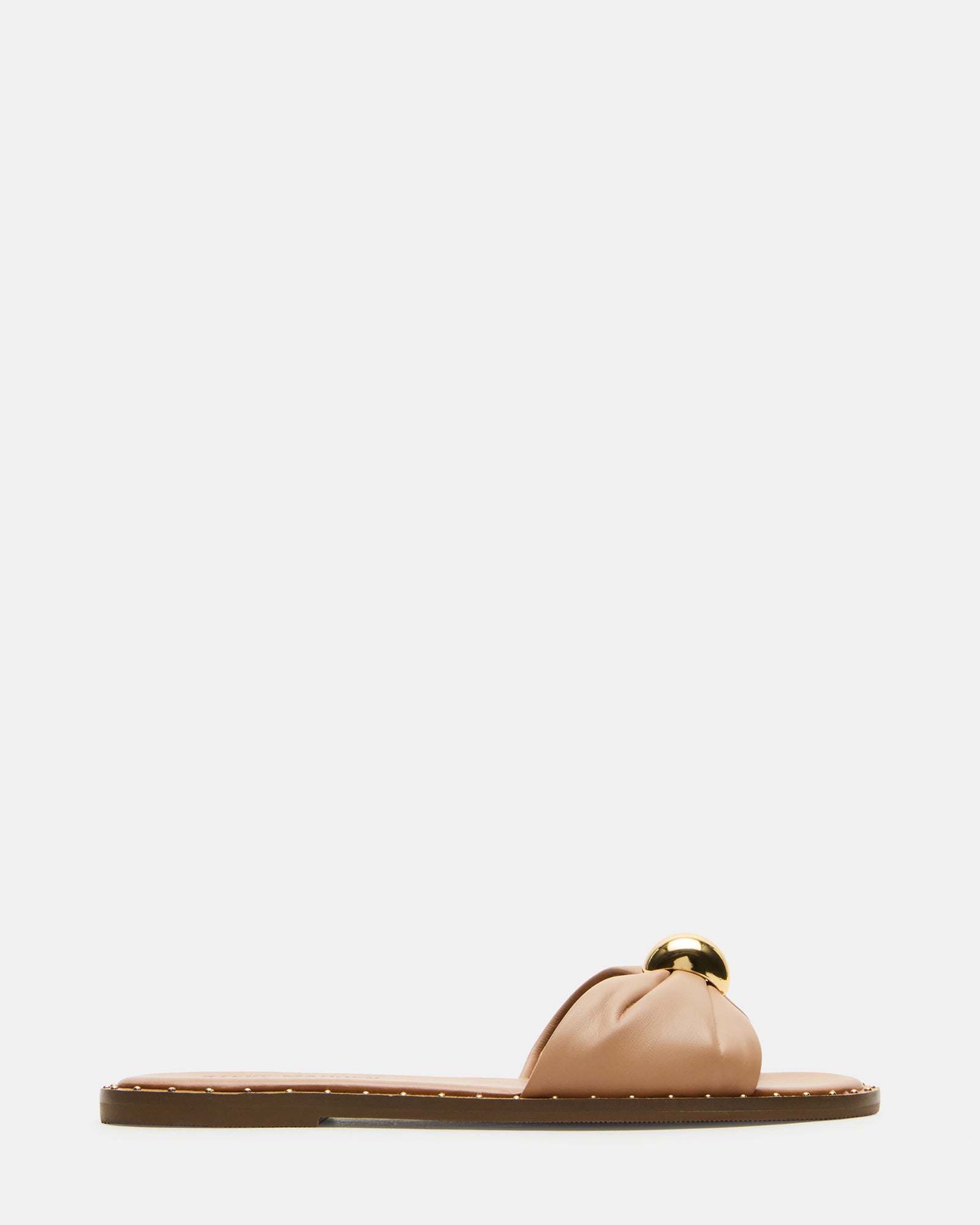 Dipsy tan leather slide sandals with mini studs and rounded toe on a wooden surface