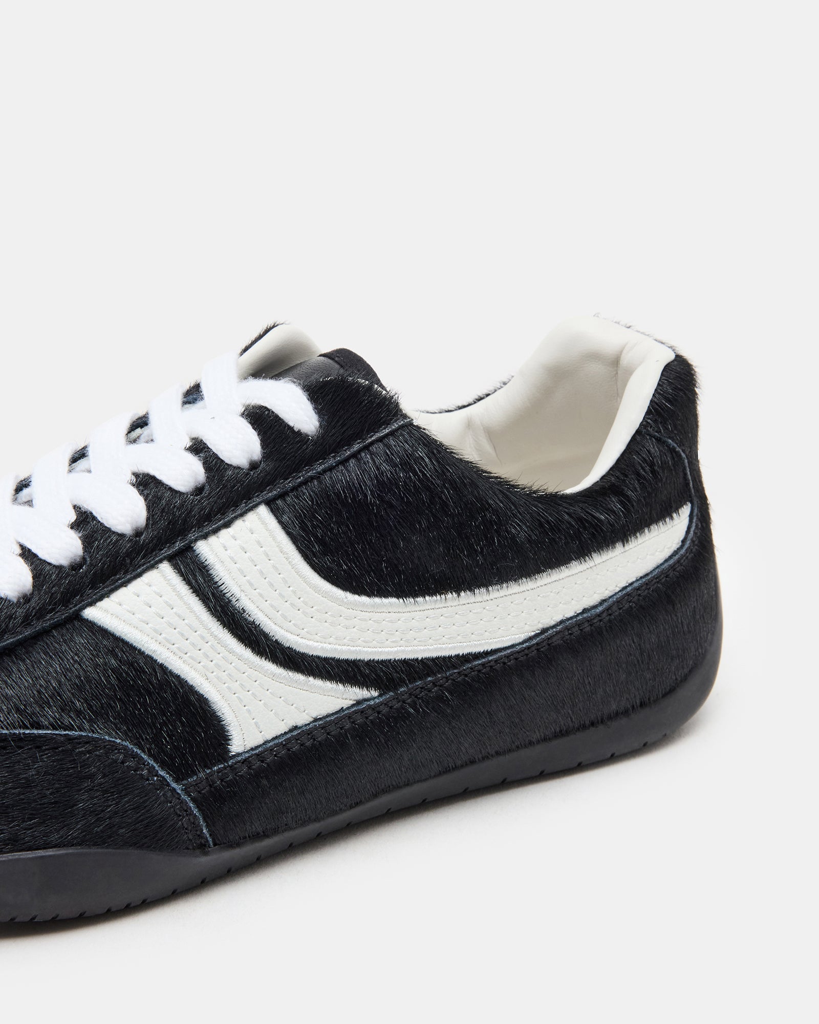 Close-up of lace-up details and heel stitching on DOBSON sneakers in natural light