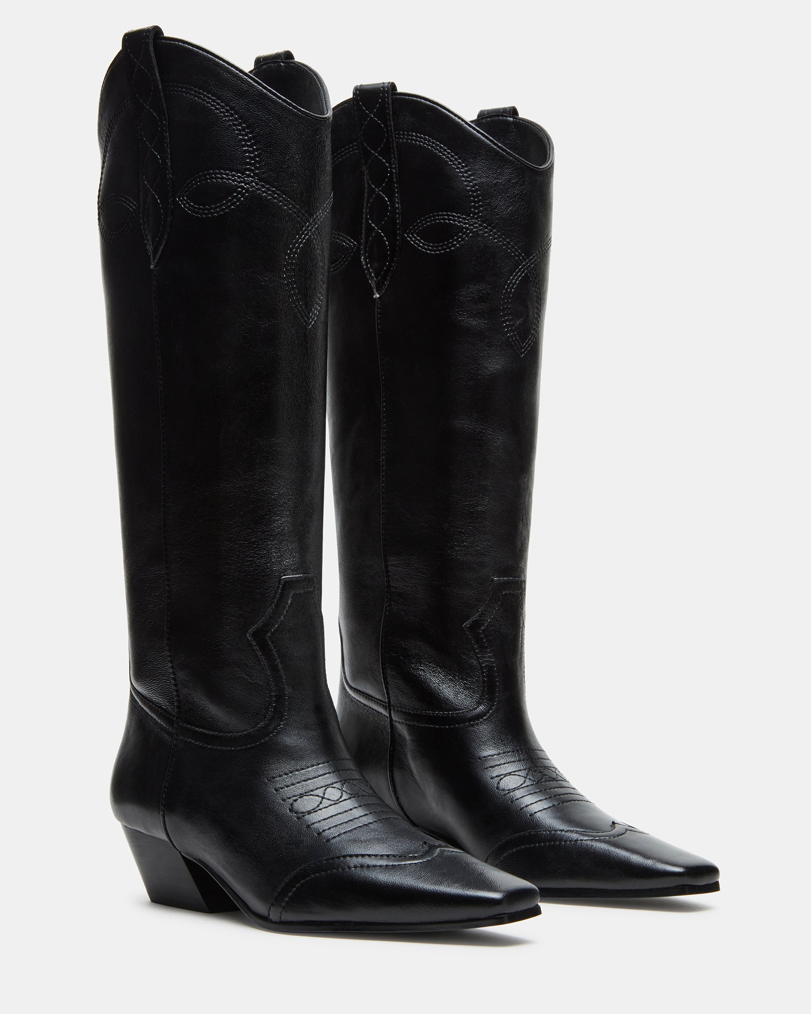 Dollie black leather boots worn outdoors in a casual setting.