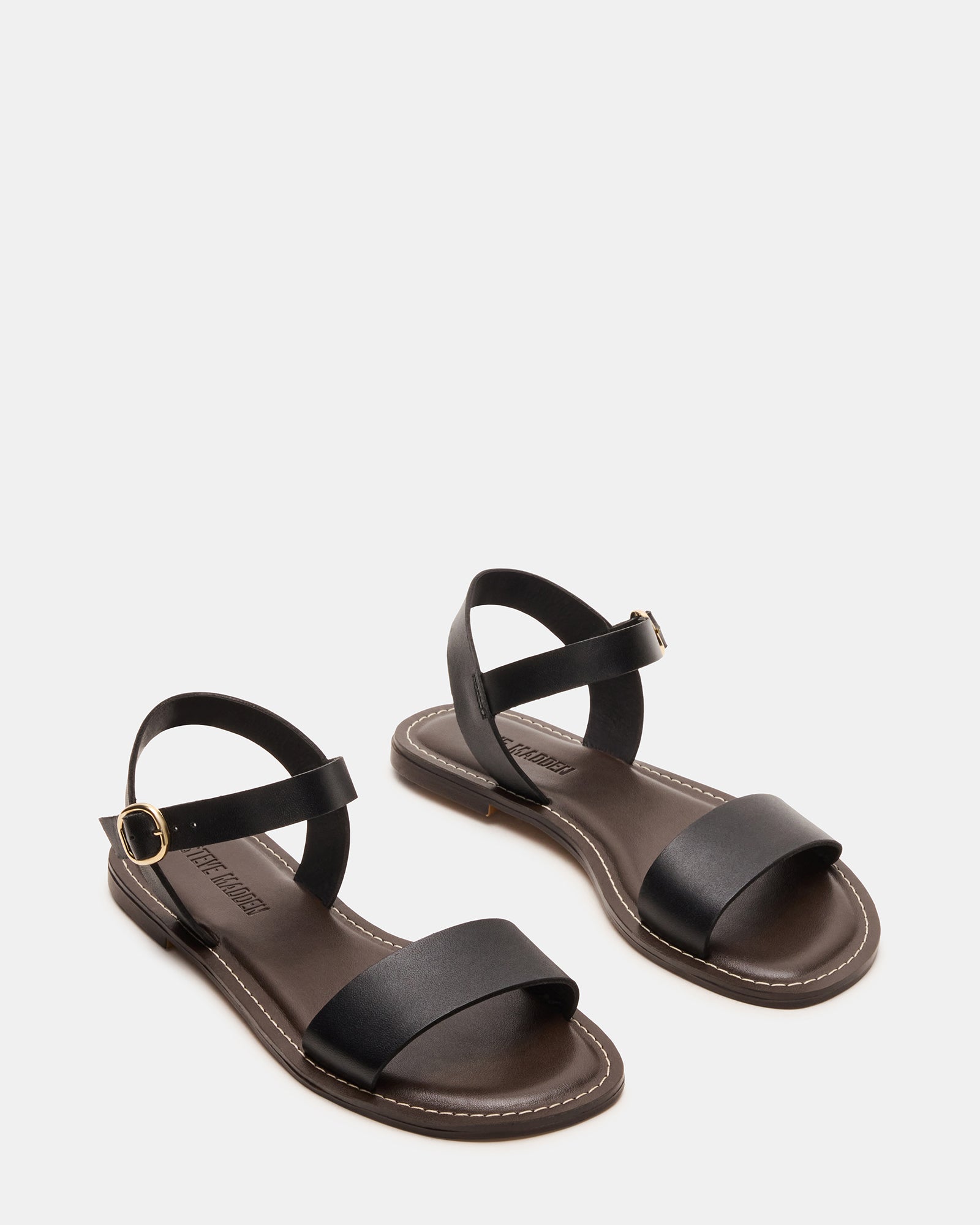 Model wearing comfortable black flat sandals, perfect for a summer day out.