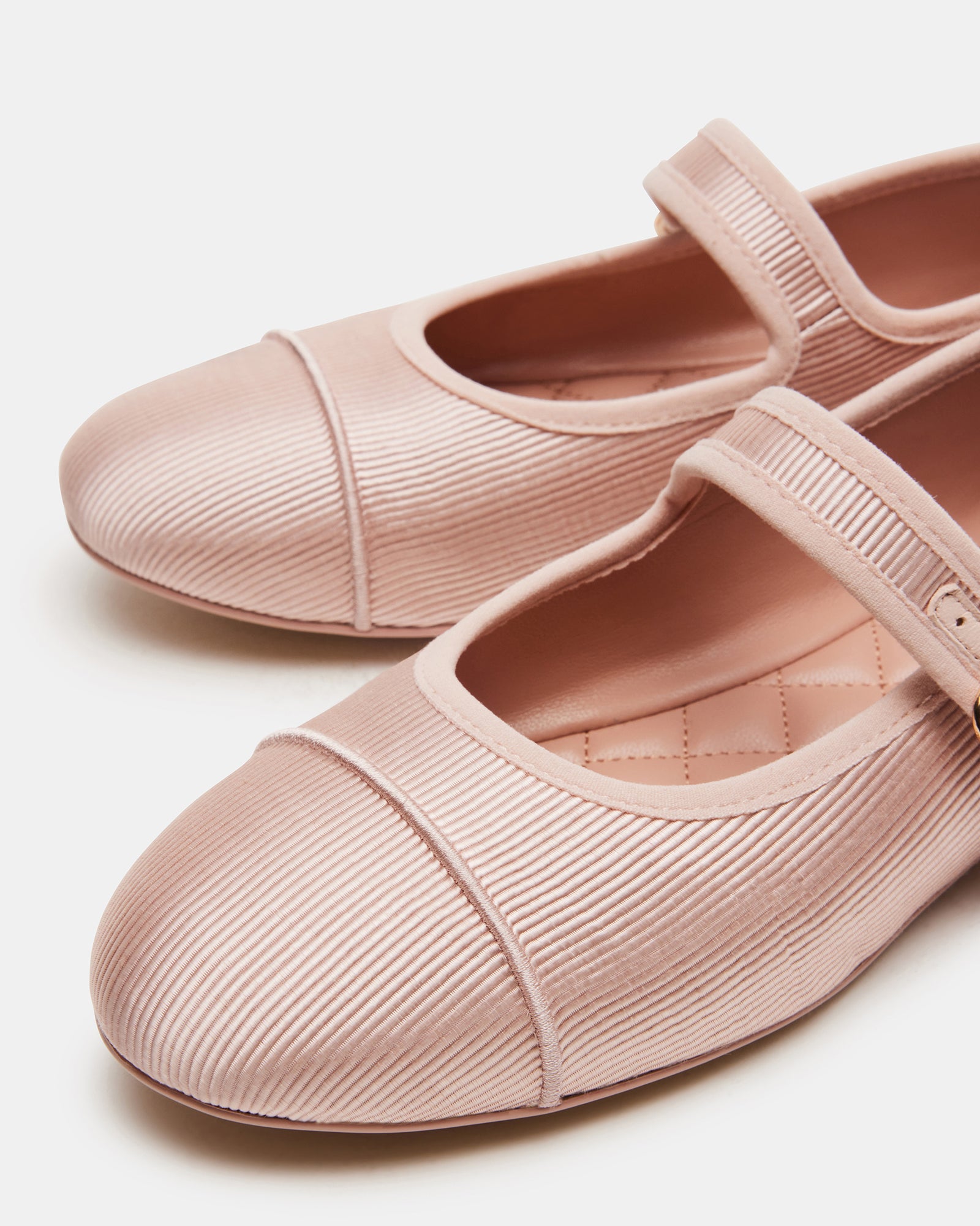 Lifestyle image of black ballet flats worn with casual denim, captured on a sunny sidewalk.