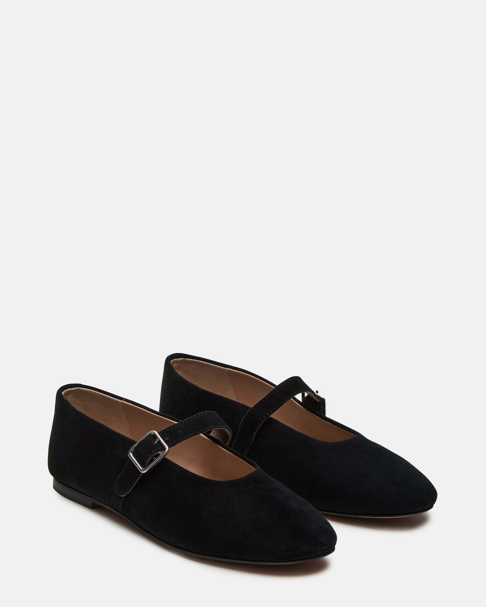 Black suede mary jane ballet flats worn during a fashionable city stroll.