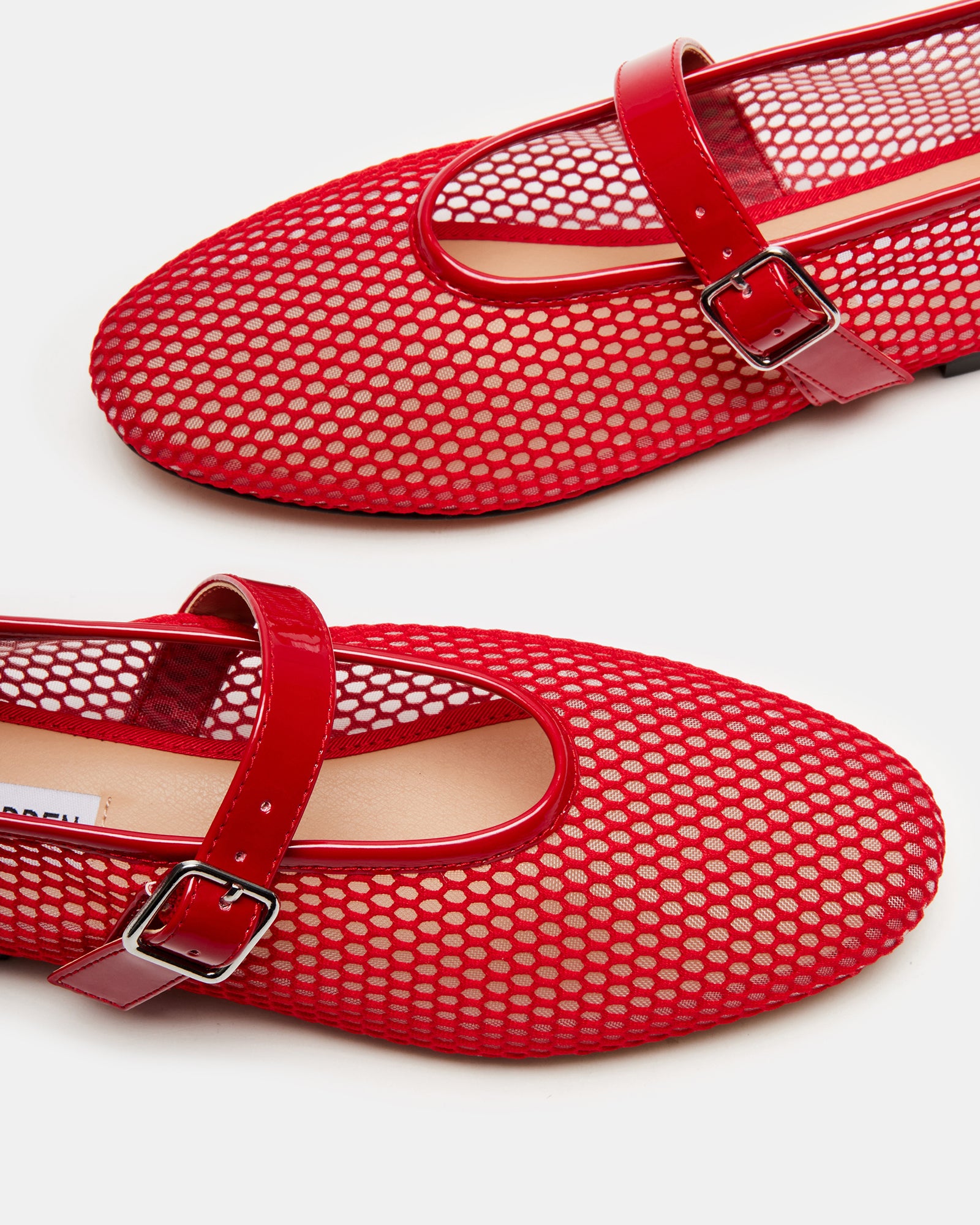Side view of red ballet flats showcasing mesh design and comfort.