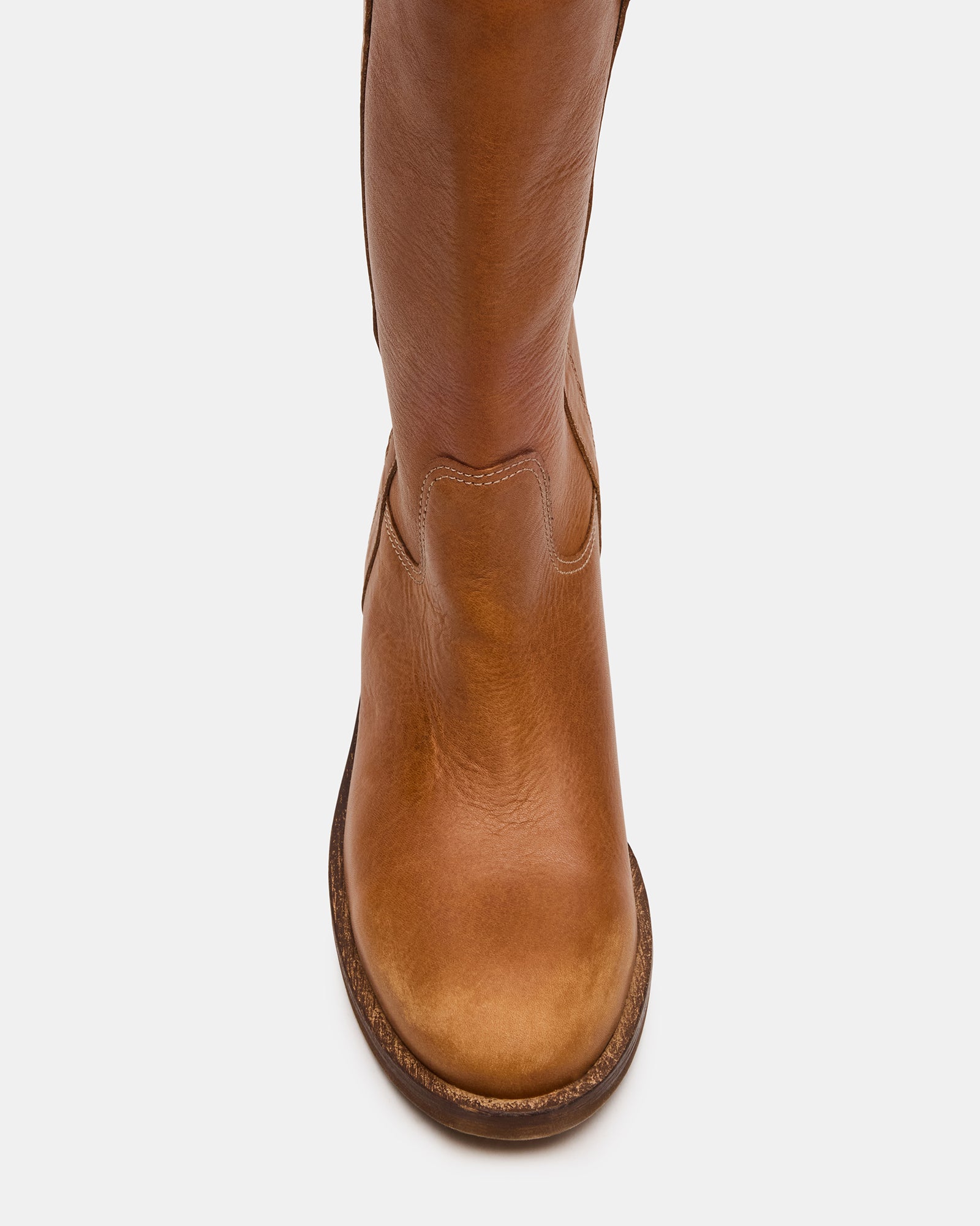 Side view of Dunster tan leather boots on a wooden porch, showcasing the knee-high design.