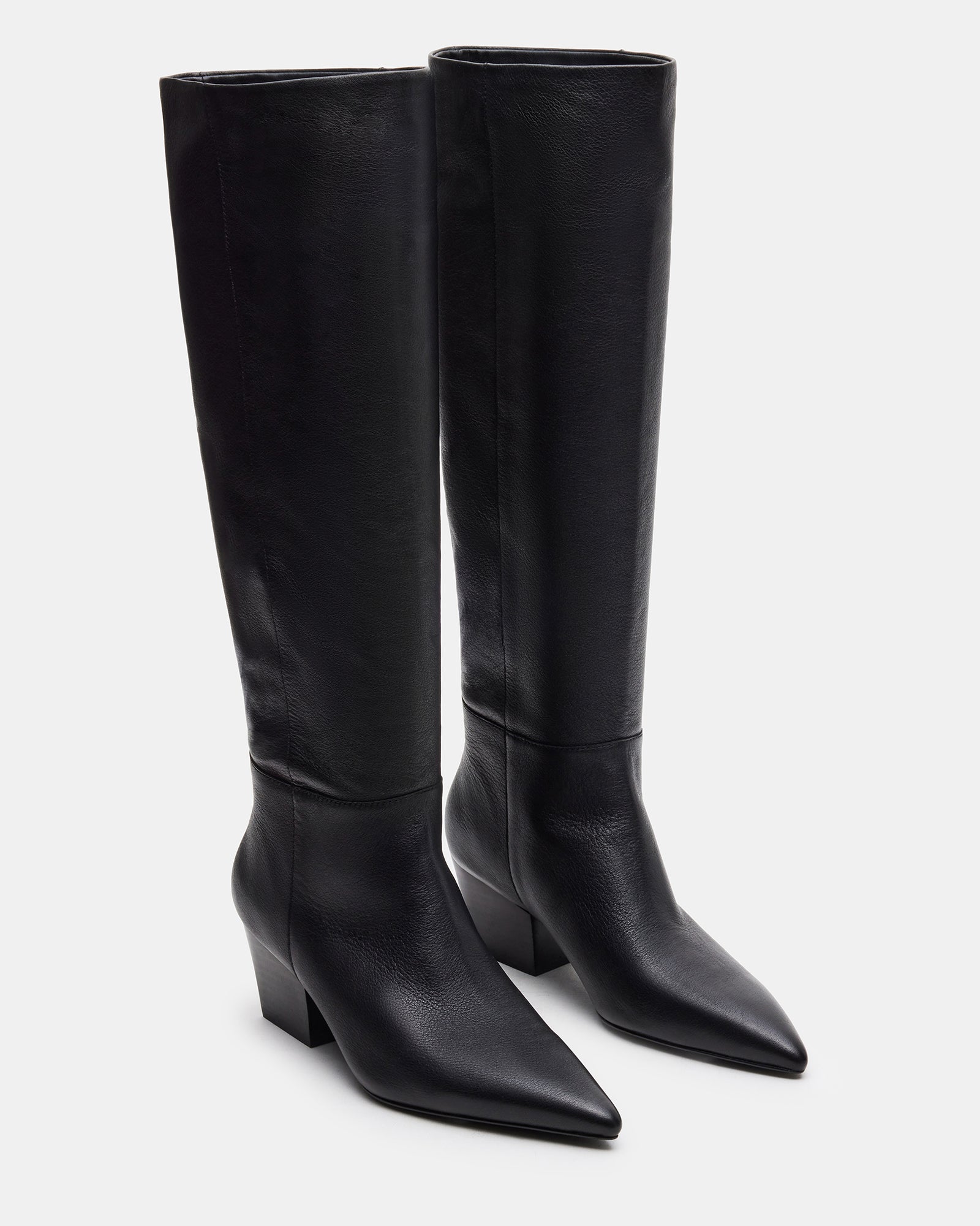 Close-up of knee high boots showing leather texture and sleek pointed silhouette.